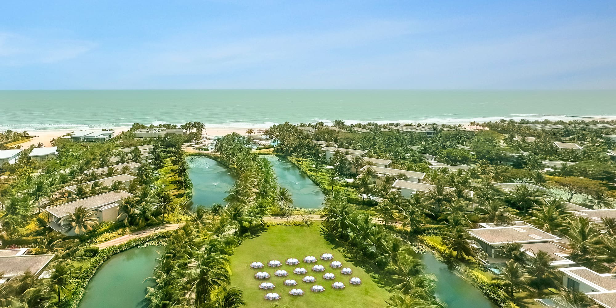 a aerial view of a resort with a body of water and a beach