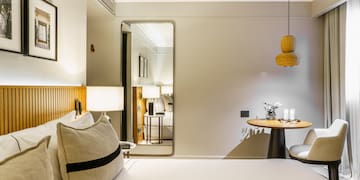 a bedroom with a round table and a lamp