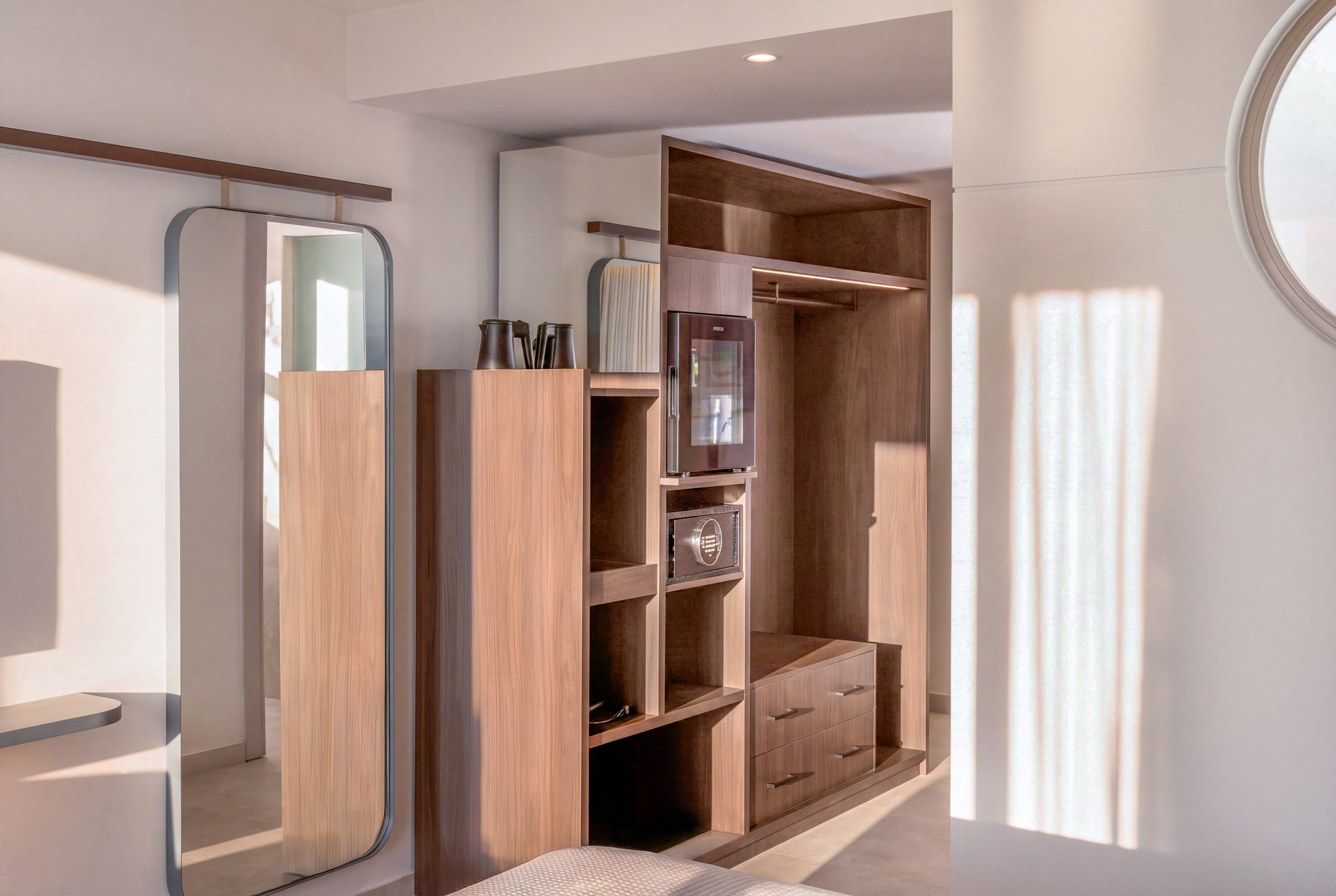Modern hotel room wardrobe with mirror, minibar, safe, and yoga mat. - The INNSiDE Room サイドシービュー - INNSiDE Bugibba, ブジッバ