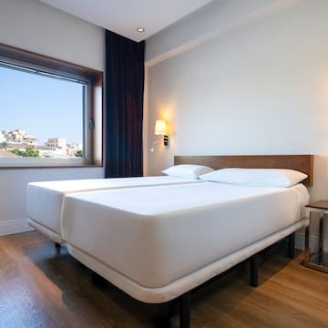 a room with two beds and a window