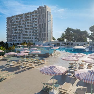 a pool with umbrellas and chairs and a building