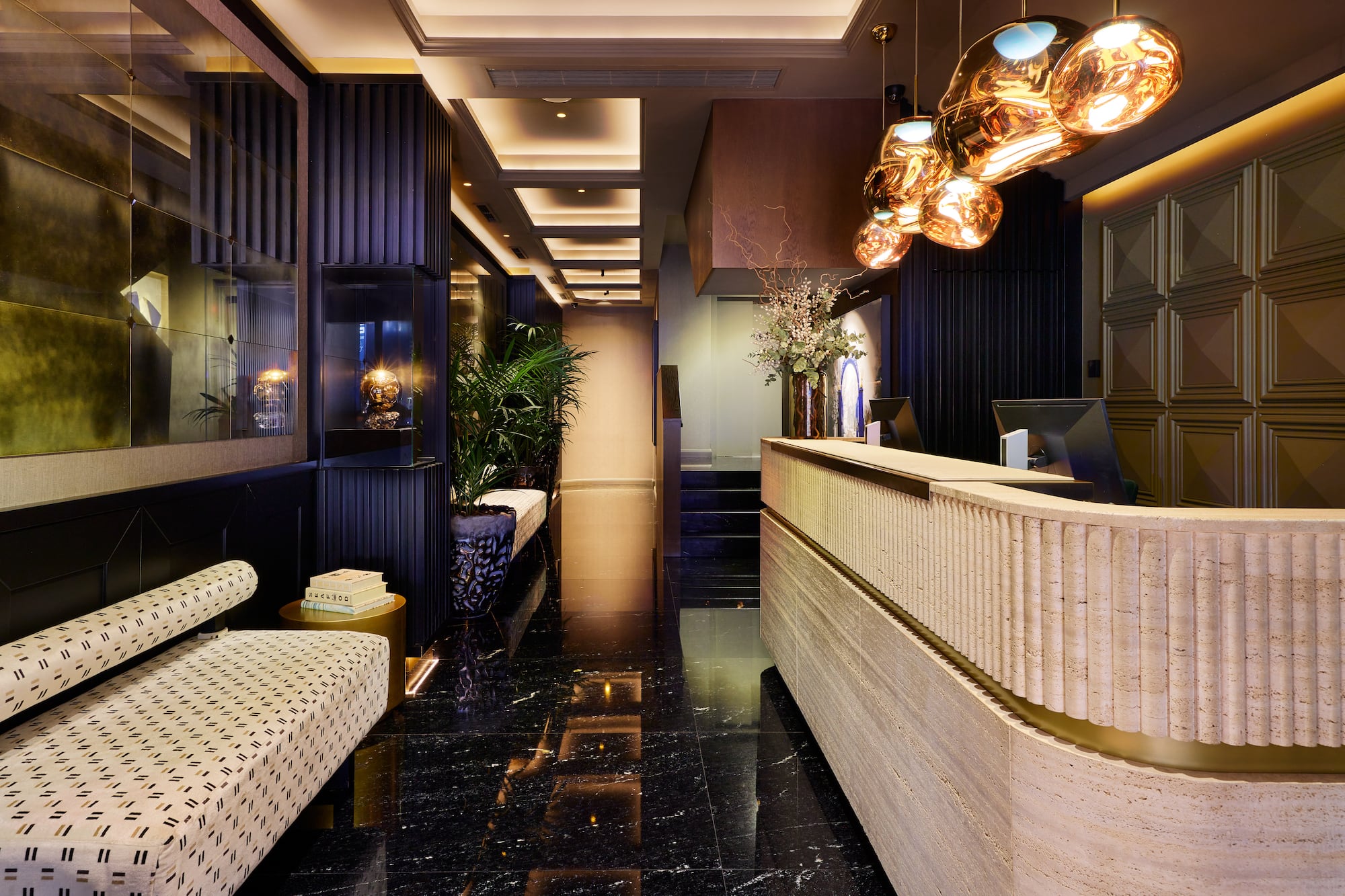 Luxury hotel lobby: modern reception desk, dark marble, sculptural lighting.