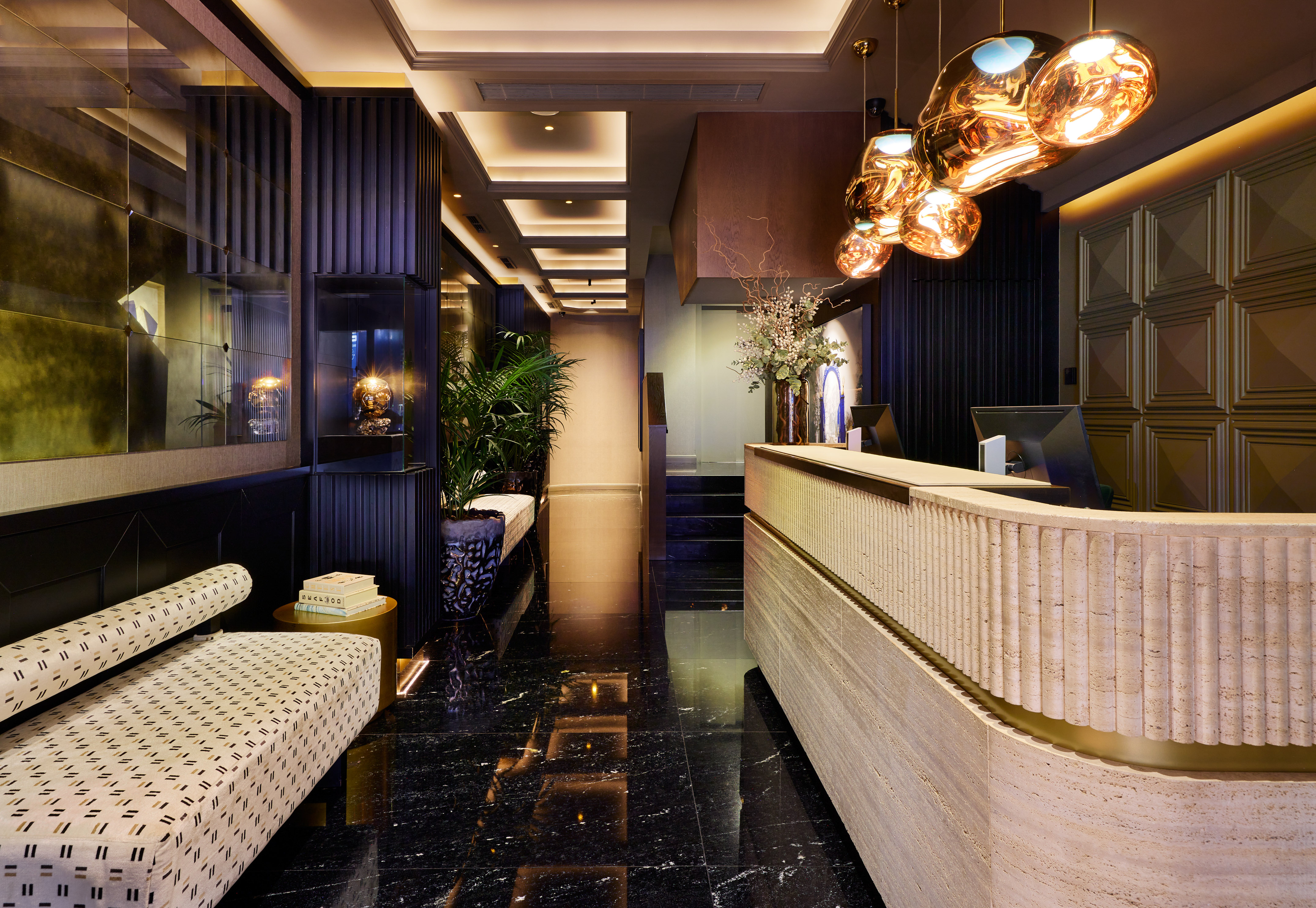 Luxury hotel lobby: modern reception desk, dark marble, sculptural lighting.