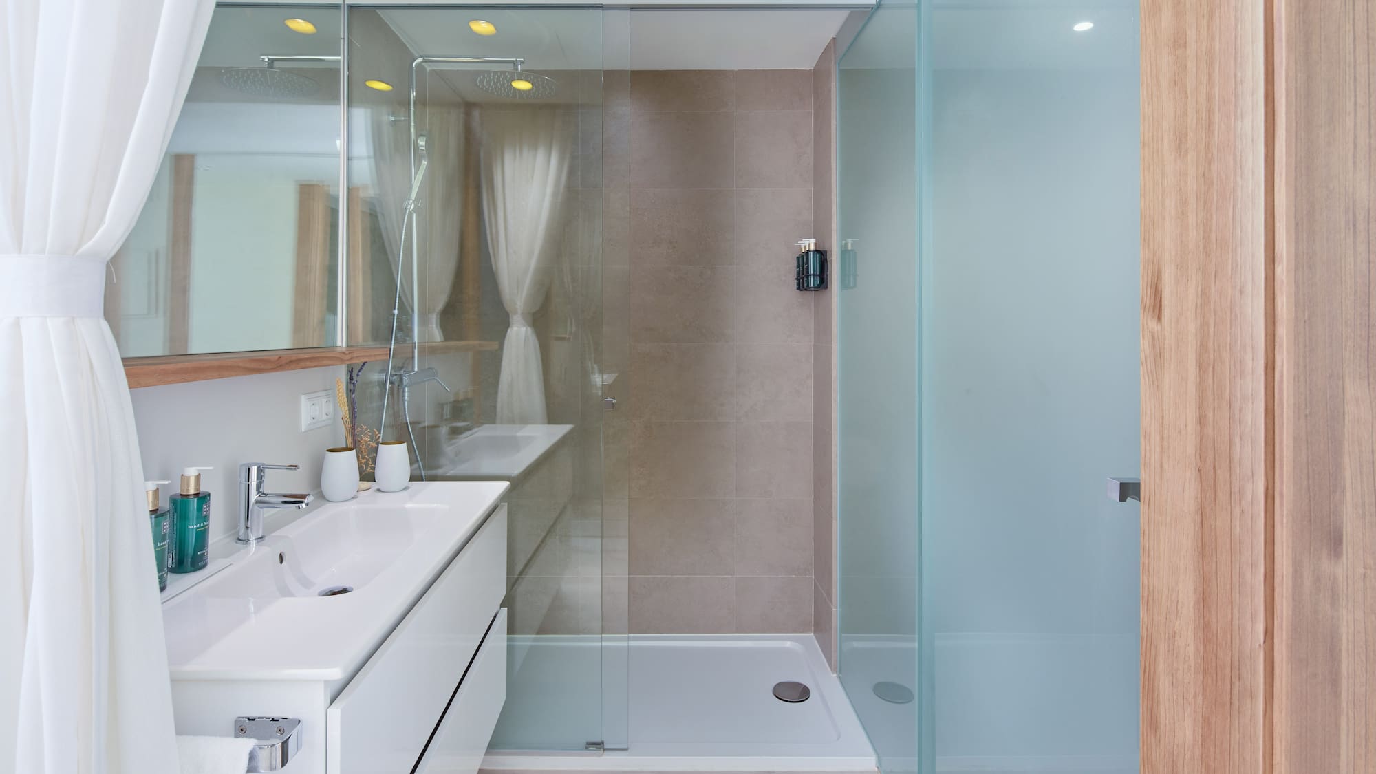 a bathroom with a glass shower and sink