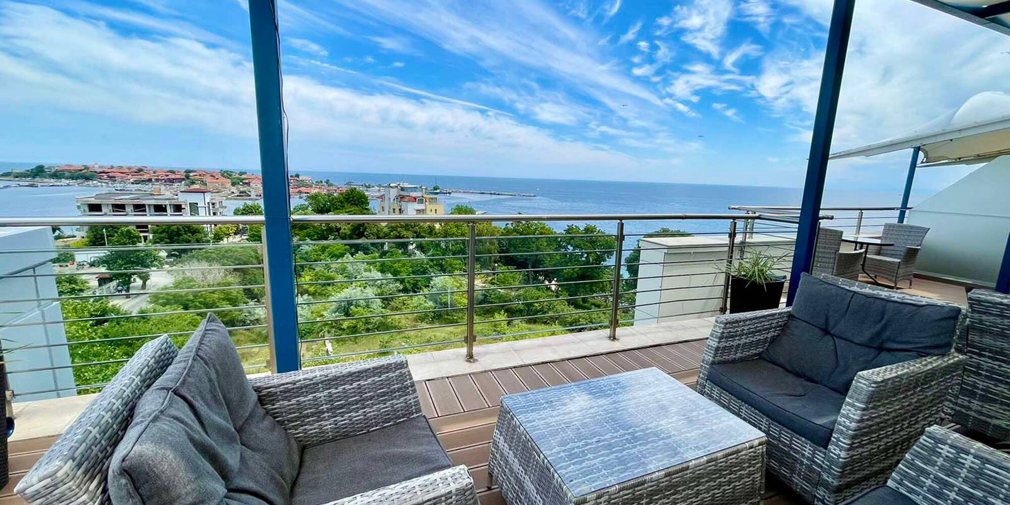 a patio with chairs and a table overlooking the ocean