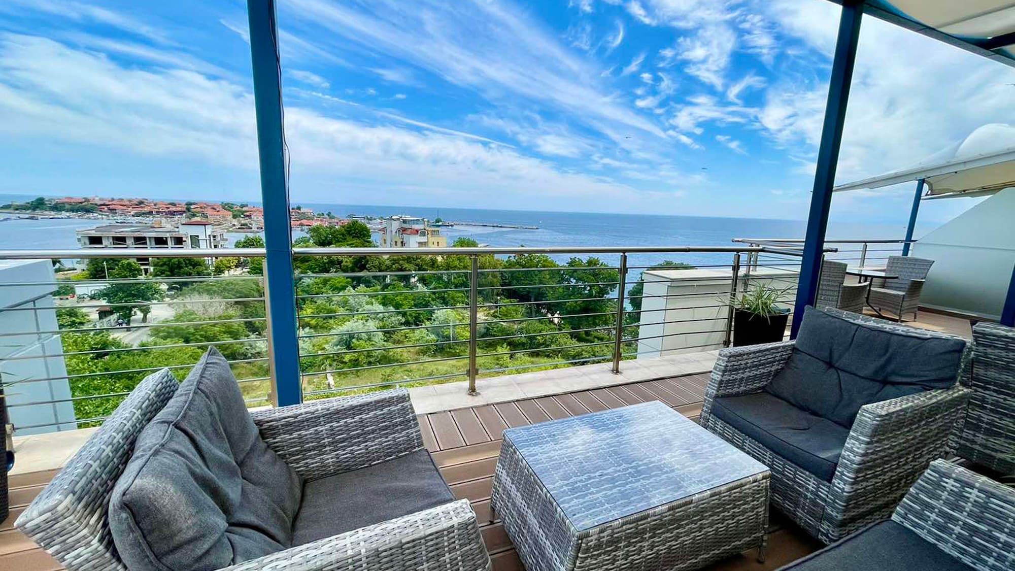 a patio with chairs and a table overlooking the ocean