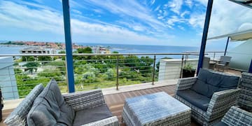 a patio with chairs and a table overlooking the ocean