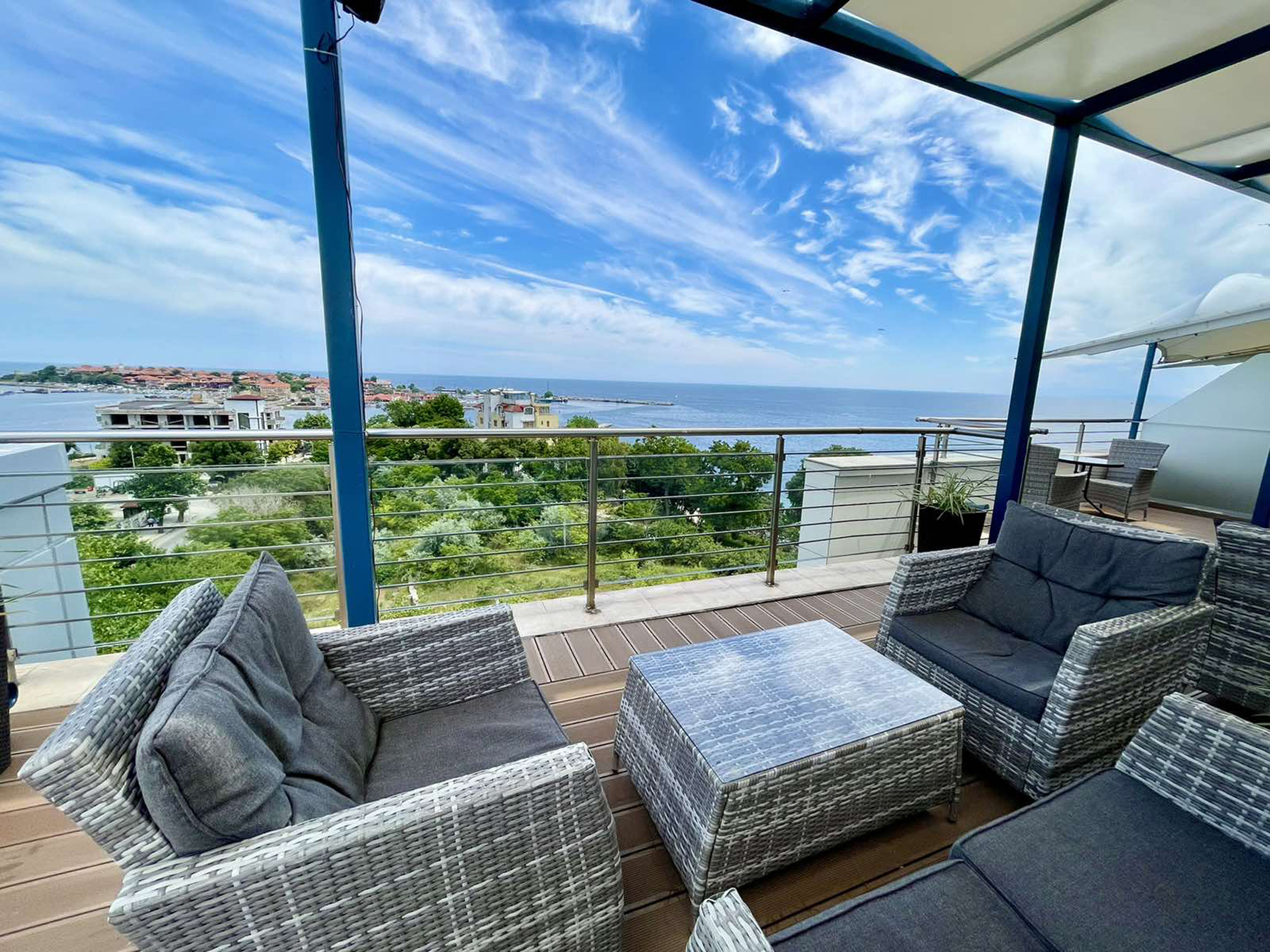 a patio with chairs and a table overlooking the ocean