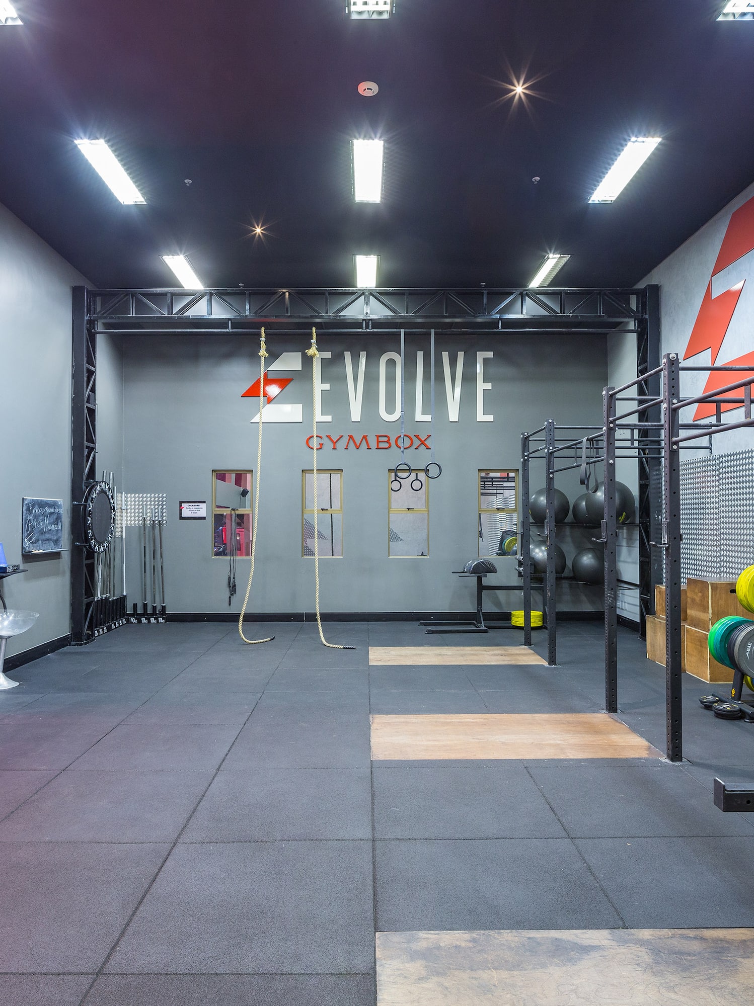 Evolve Gymbox with CrossFit equipment, rubber floor, and training rigs.