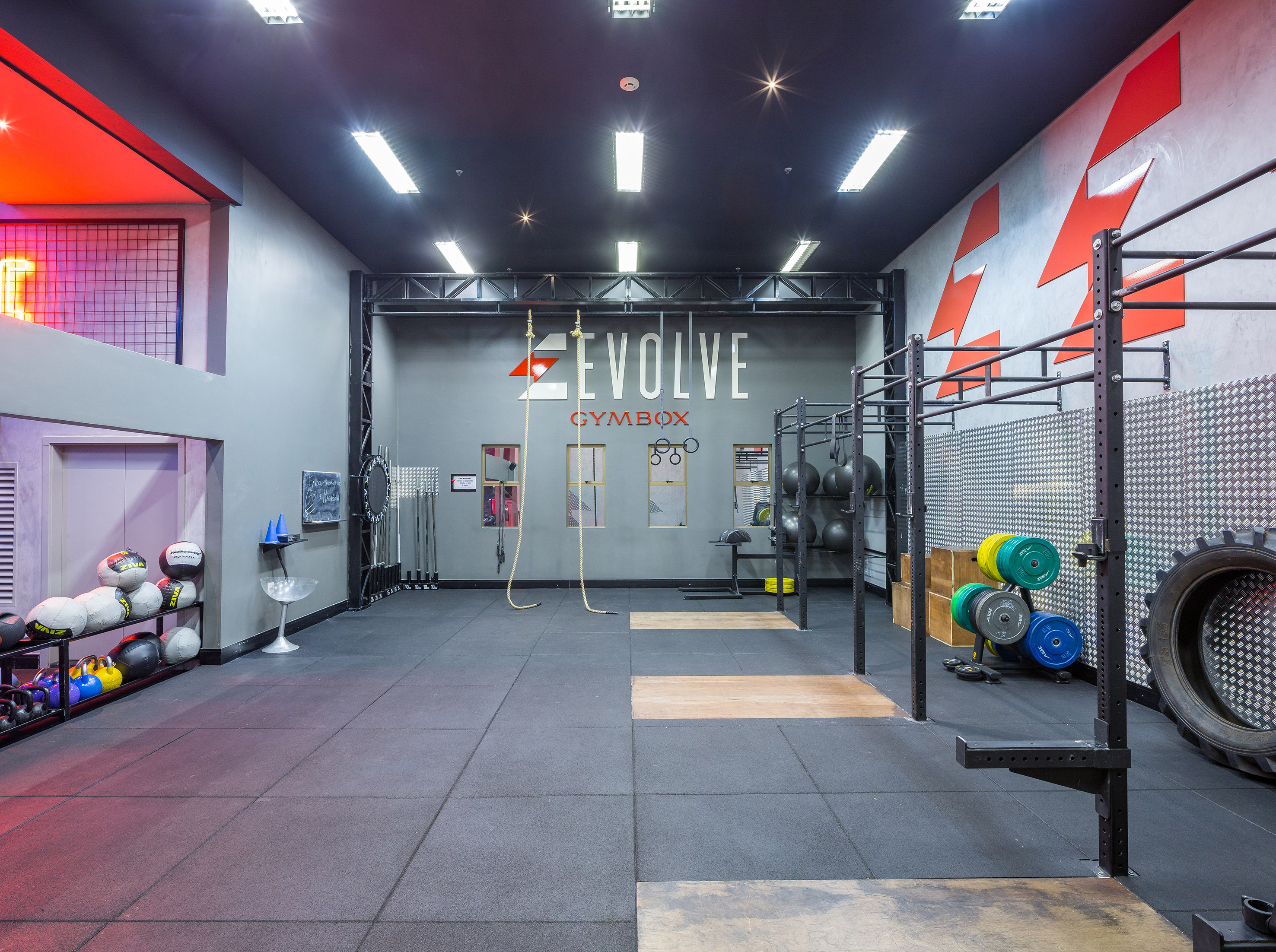Evolve Gymbox with CrossFit equipment, rubber floor, and training rigs.