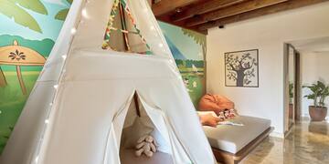 a teepee tent in a room with a bed and a bed