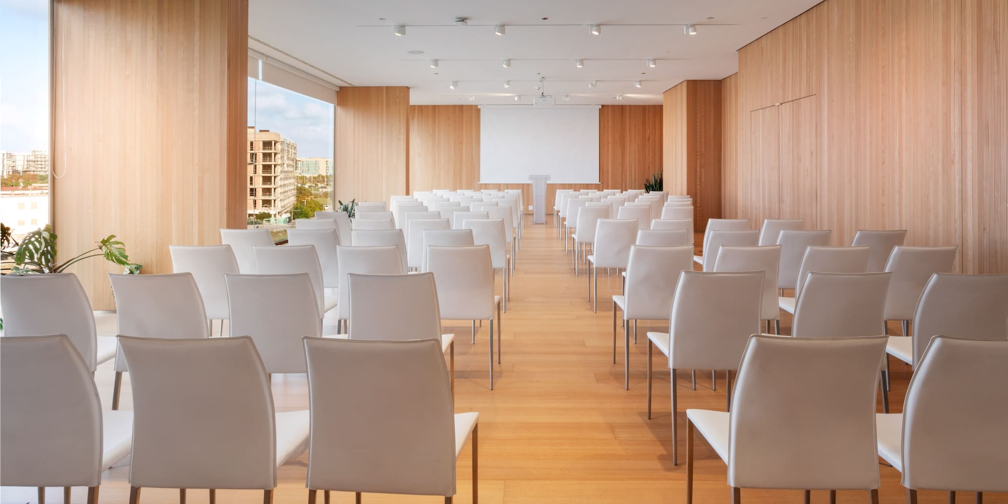 a room with white chairs and a wood floor