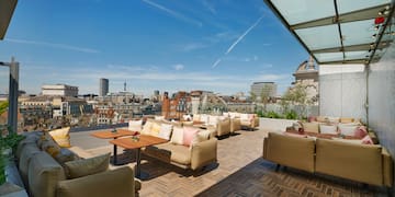 a patio with couches and tables on a rooftop