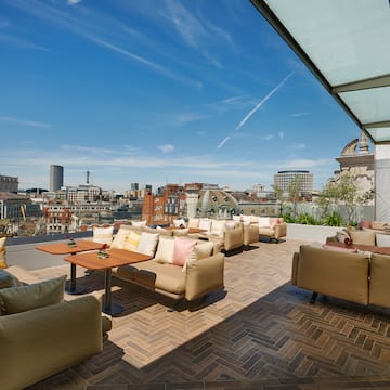 a patio with couches and tables on a rooftop