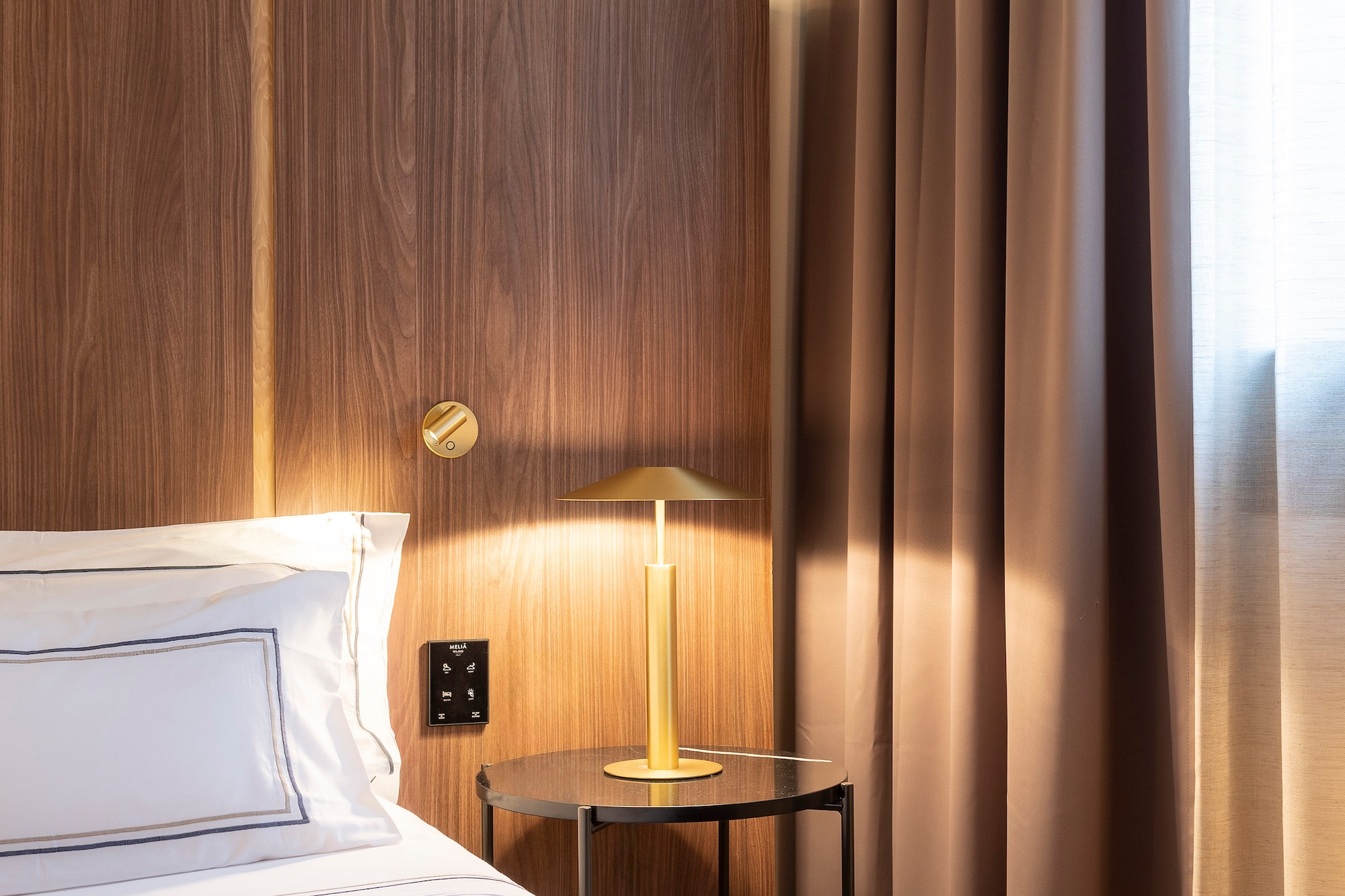 a bed with a lamp on the side of it