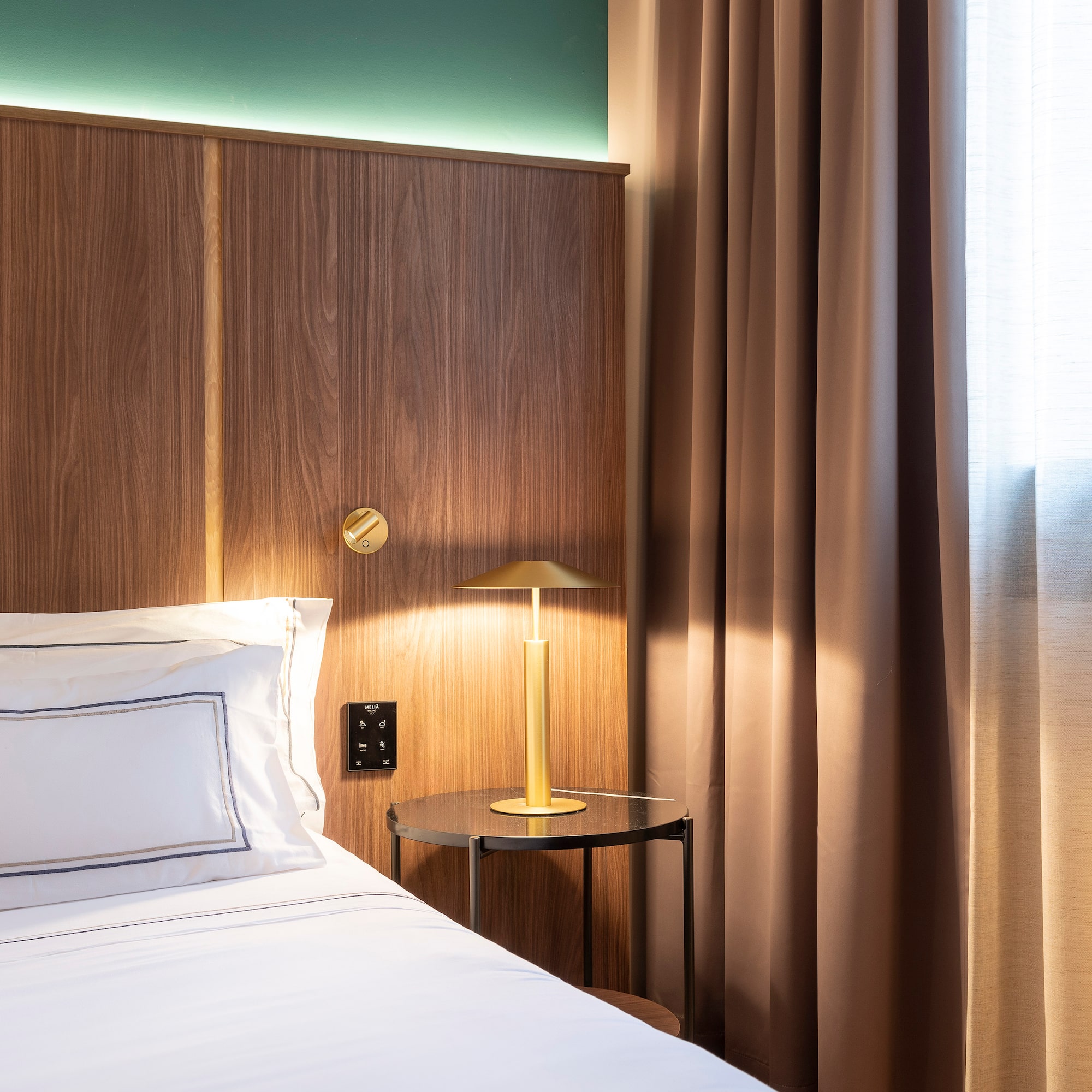 a bed with a lamp on the side of it