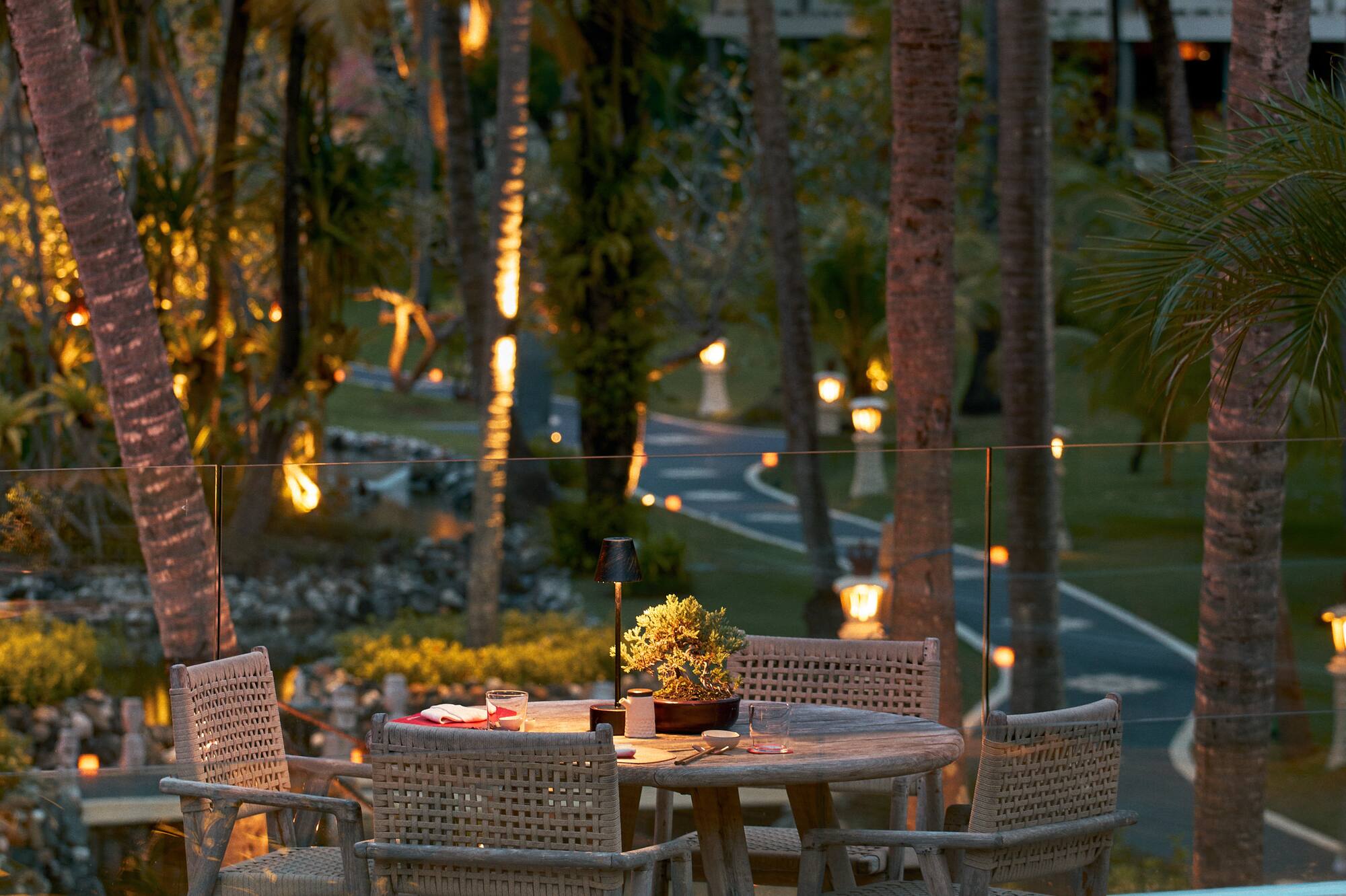 a table and chairs on a deck with trees in the background