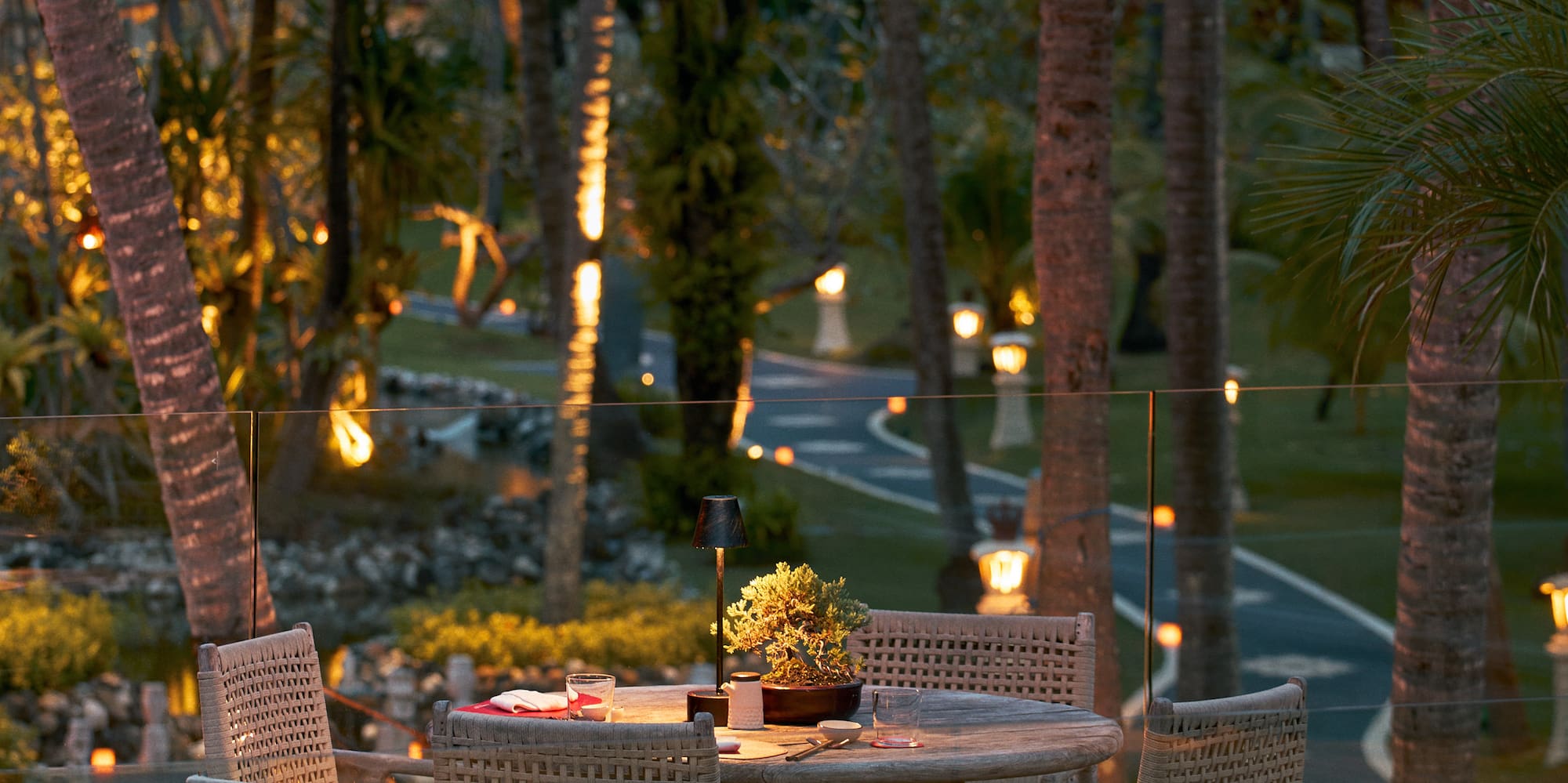 a table and chairs on a deck with trees in the background