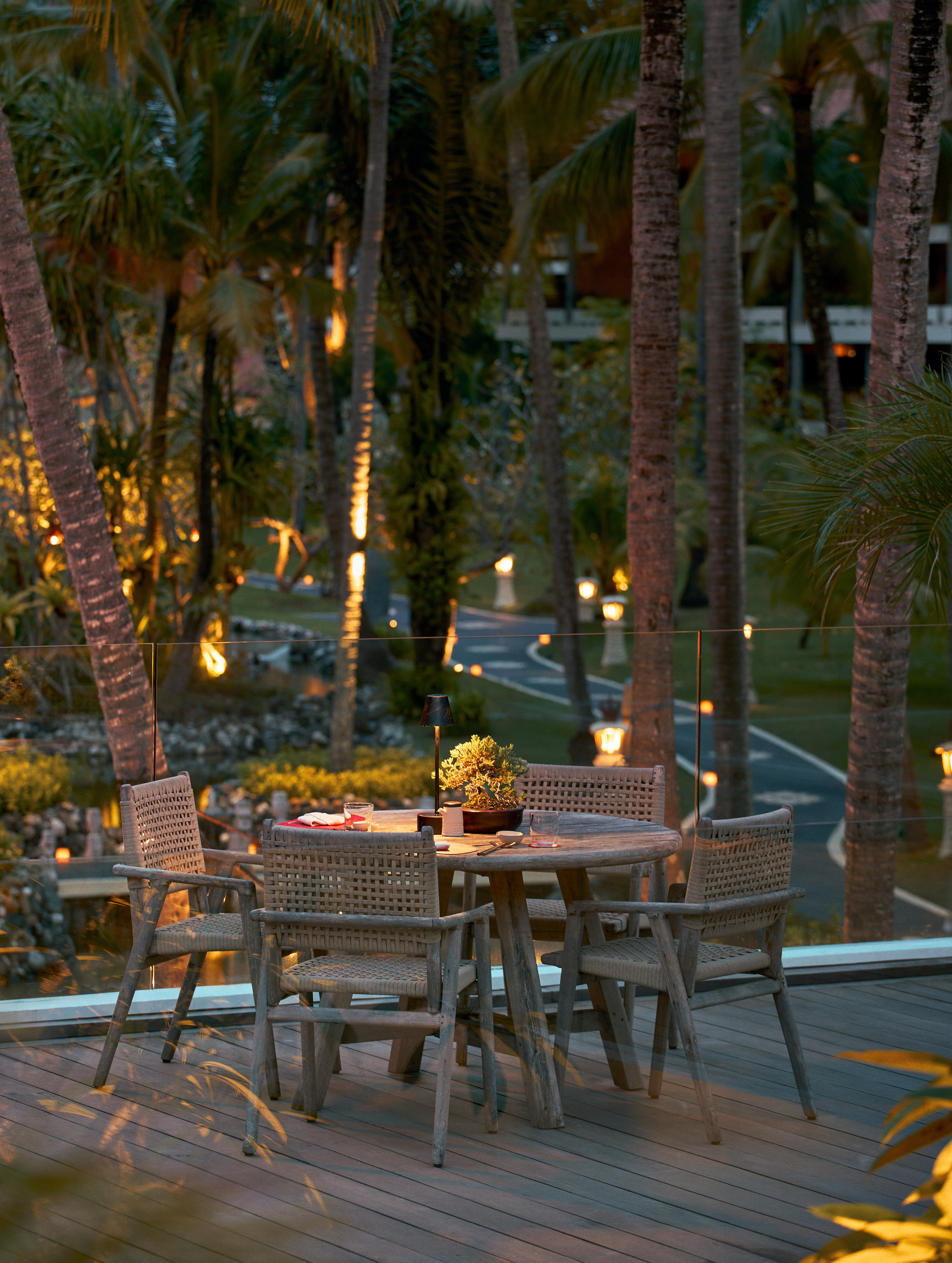 a table and chairs on a deck with trees in the background