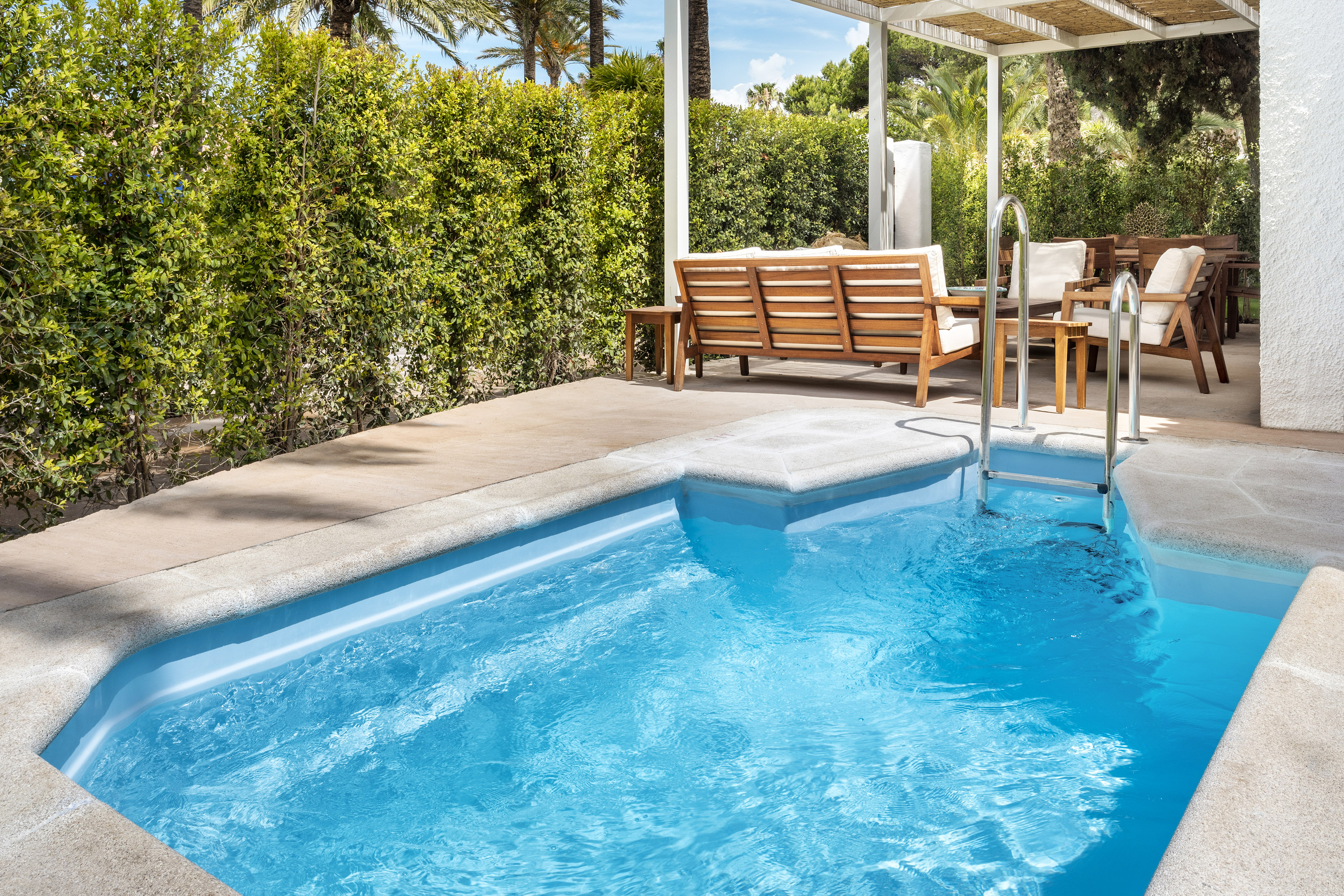 a pool with a bench and chairs