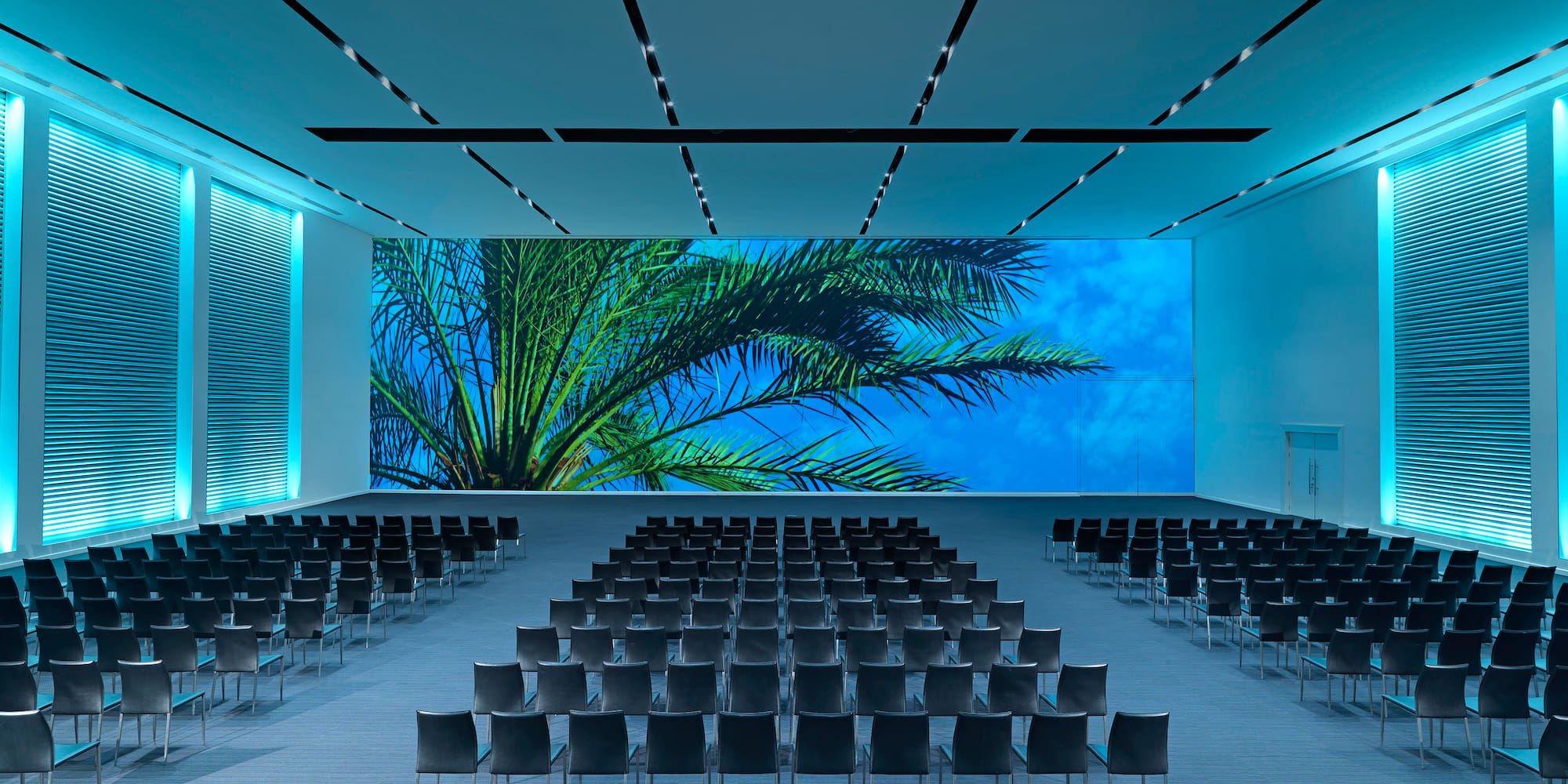 a large room with chairs and a large screen