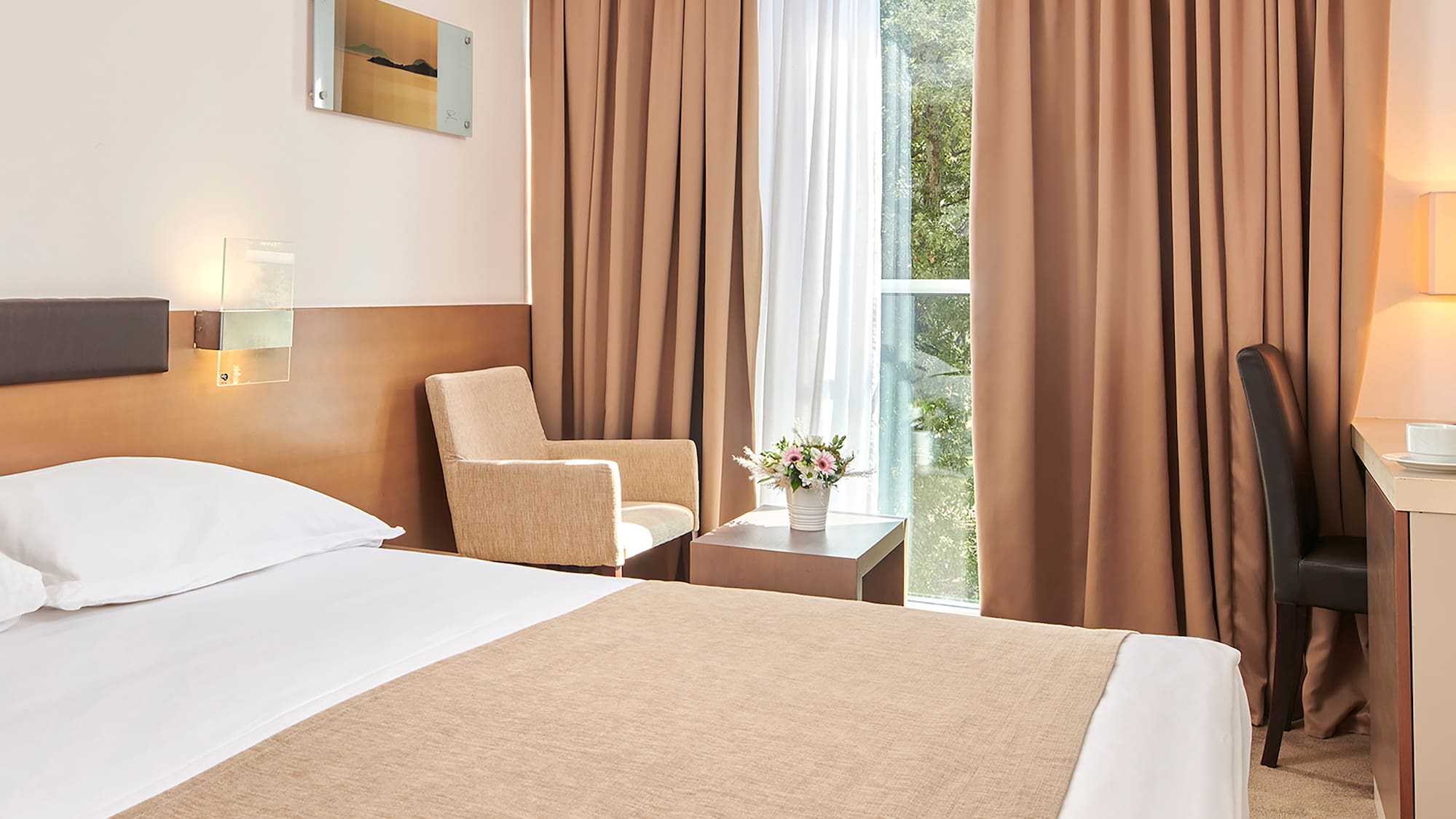 a room with a bed and a desk and chairs