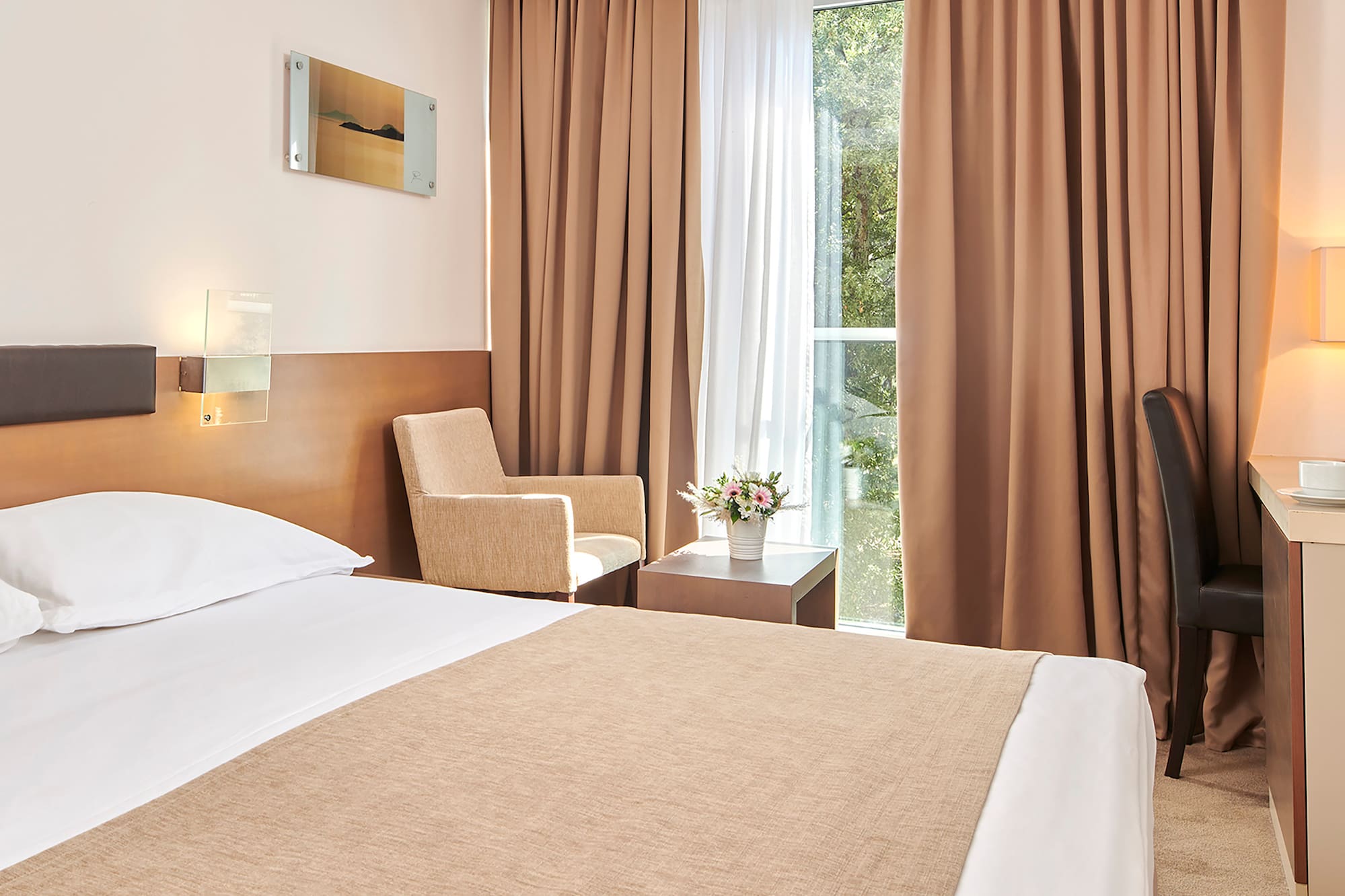 a room with a bed and a desk and chairs