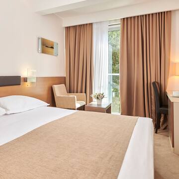 a room with a bed and a desk and chairs