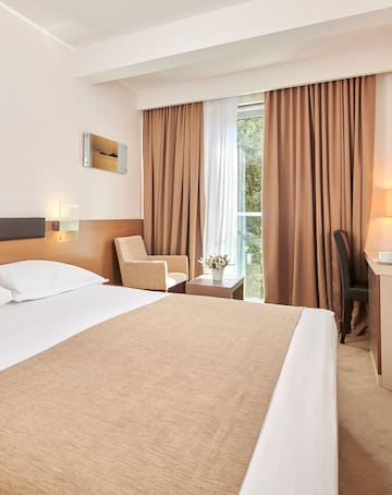 a room with a bed and a desk and chairs