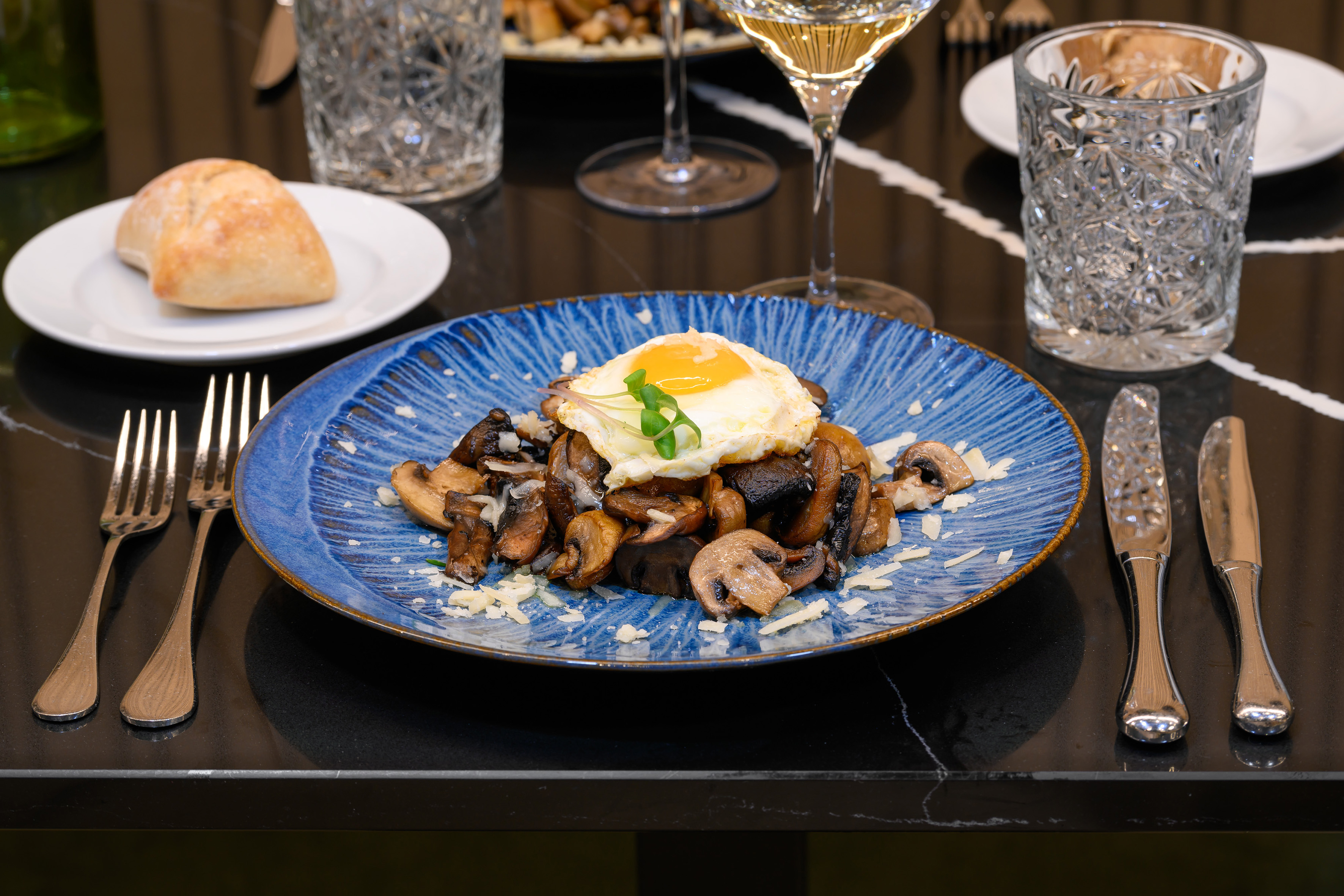 Breakfast plate with sautéed mushrooms, fried egg, and parmesan.