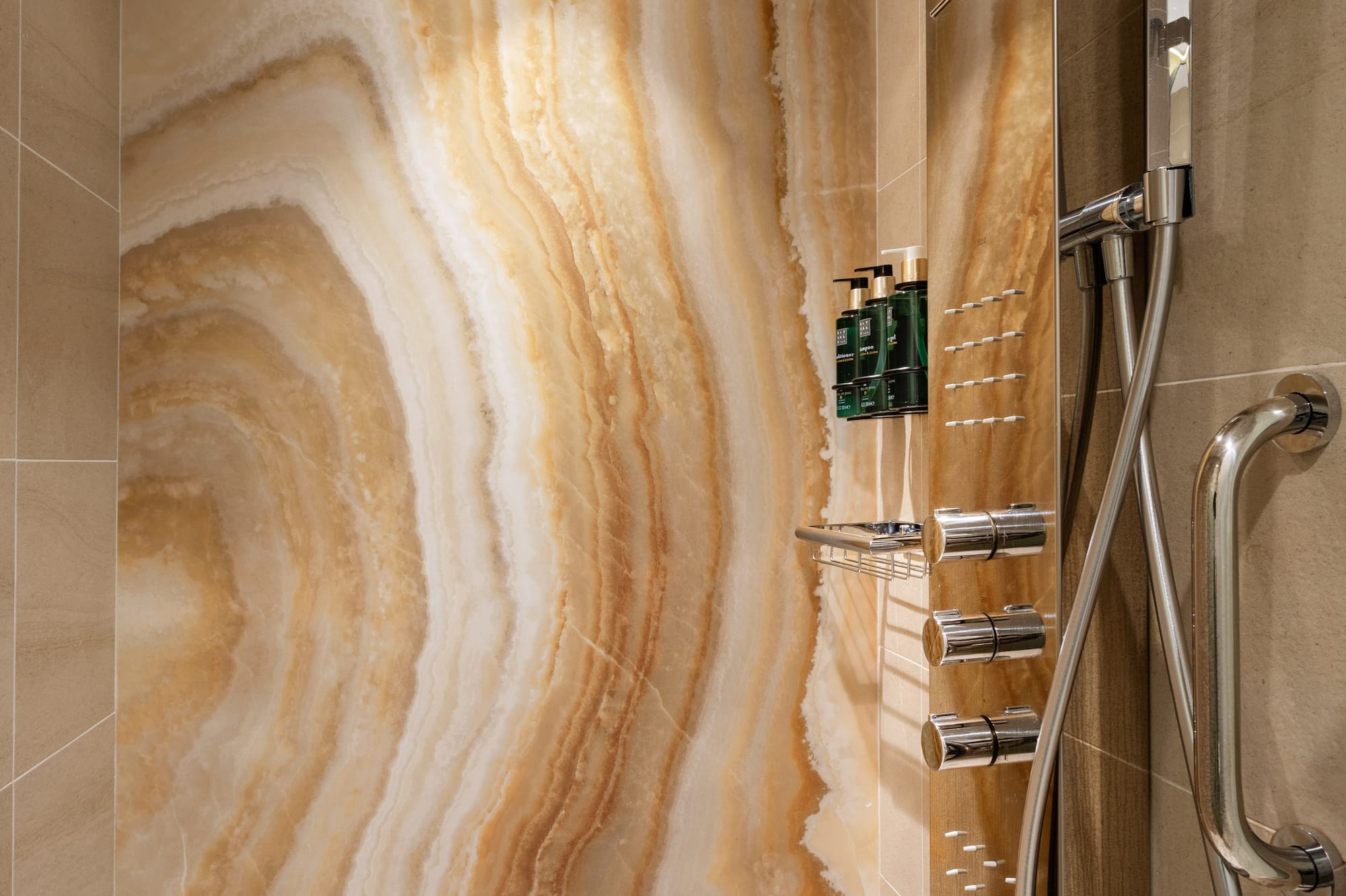 a shower with a marble wall