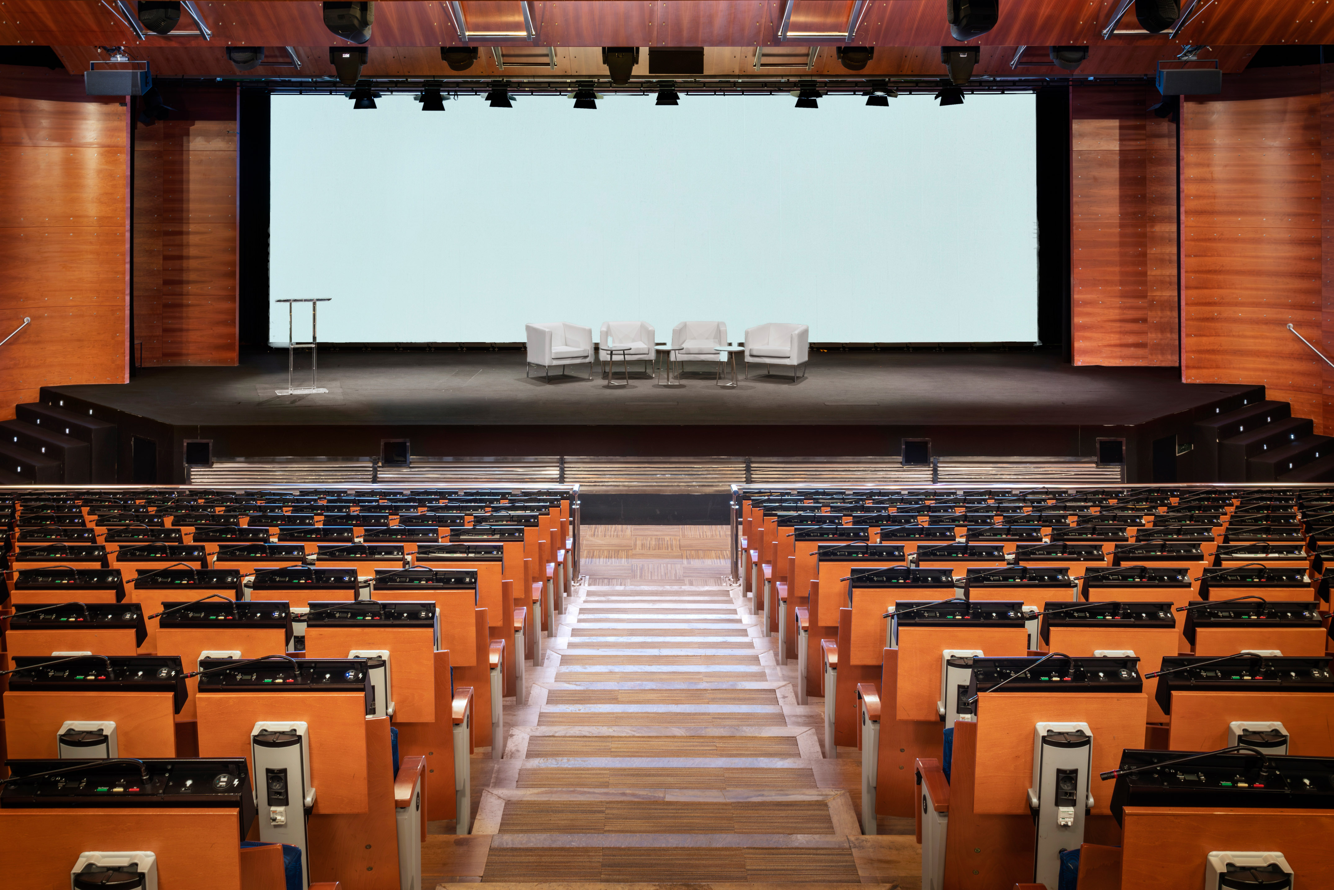 a stage with chairs and a large screen