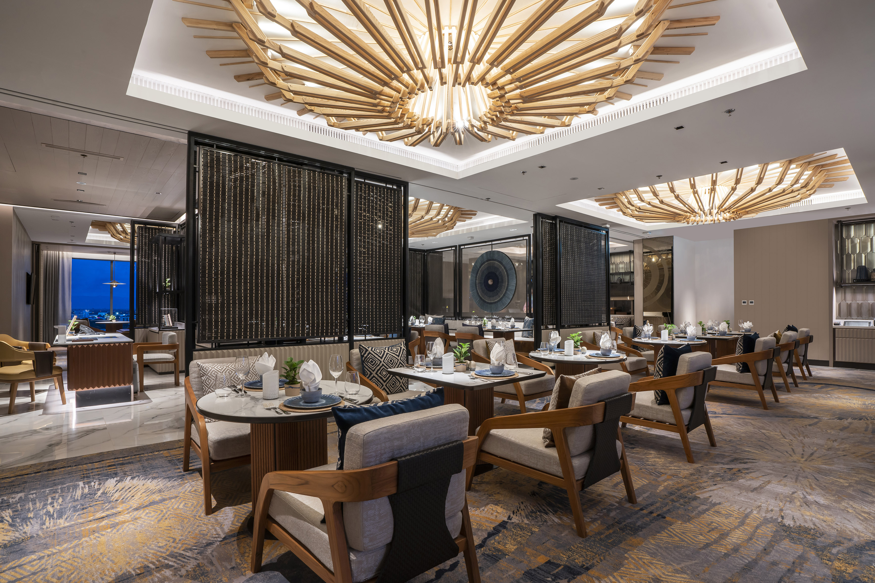 Modern luxury restaurant with unique wooden chandelier and elegant dining tables.