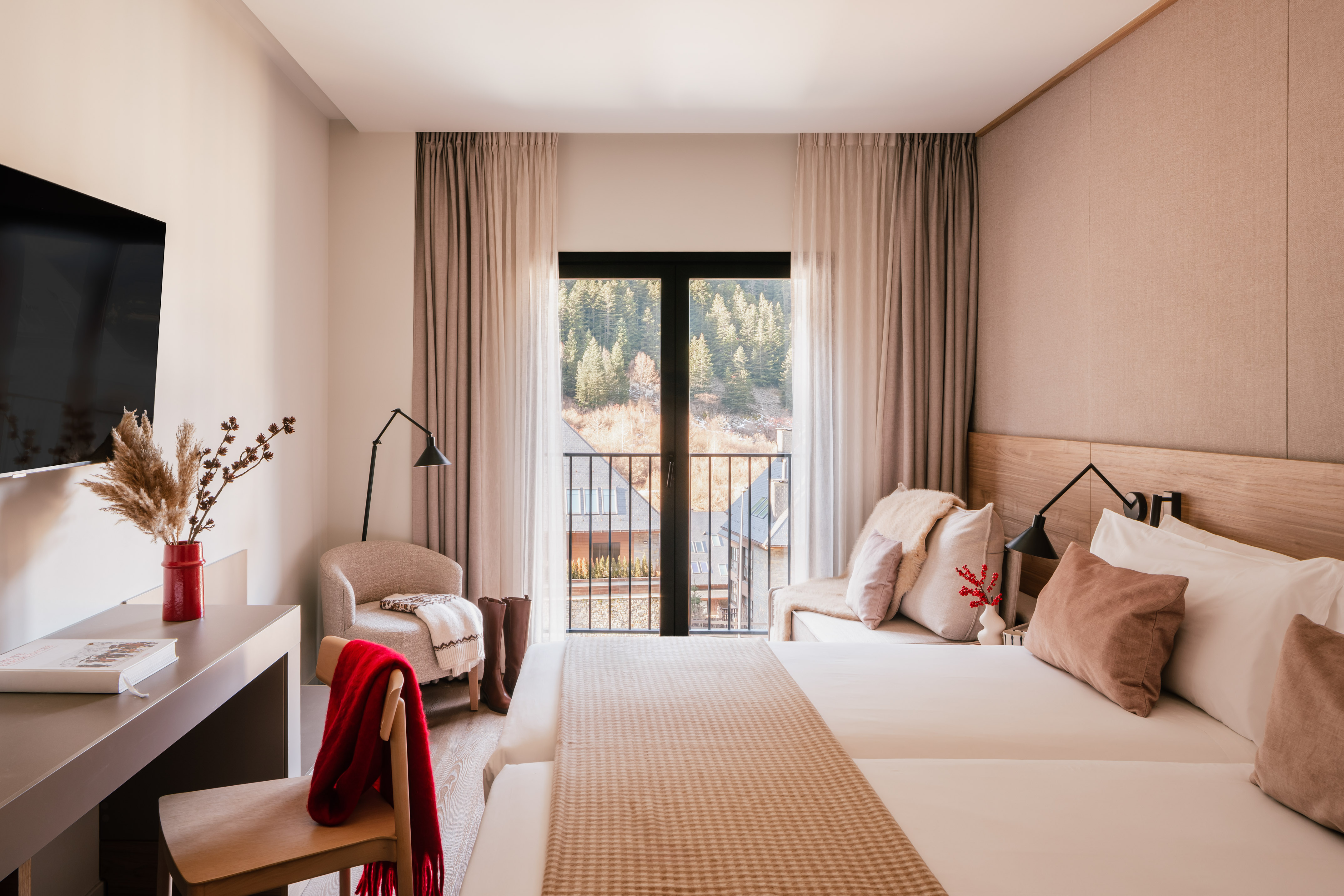 Cozy hotel bedroom with mountain view balcony, twin beds, and modern decor.
