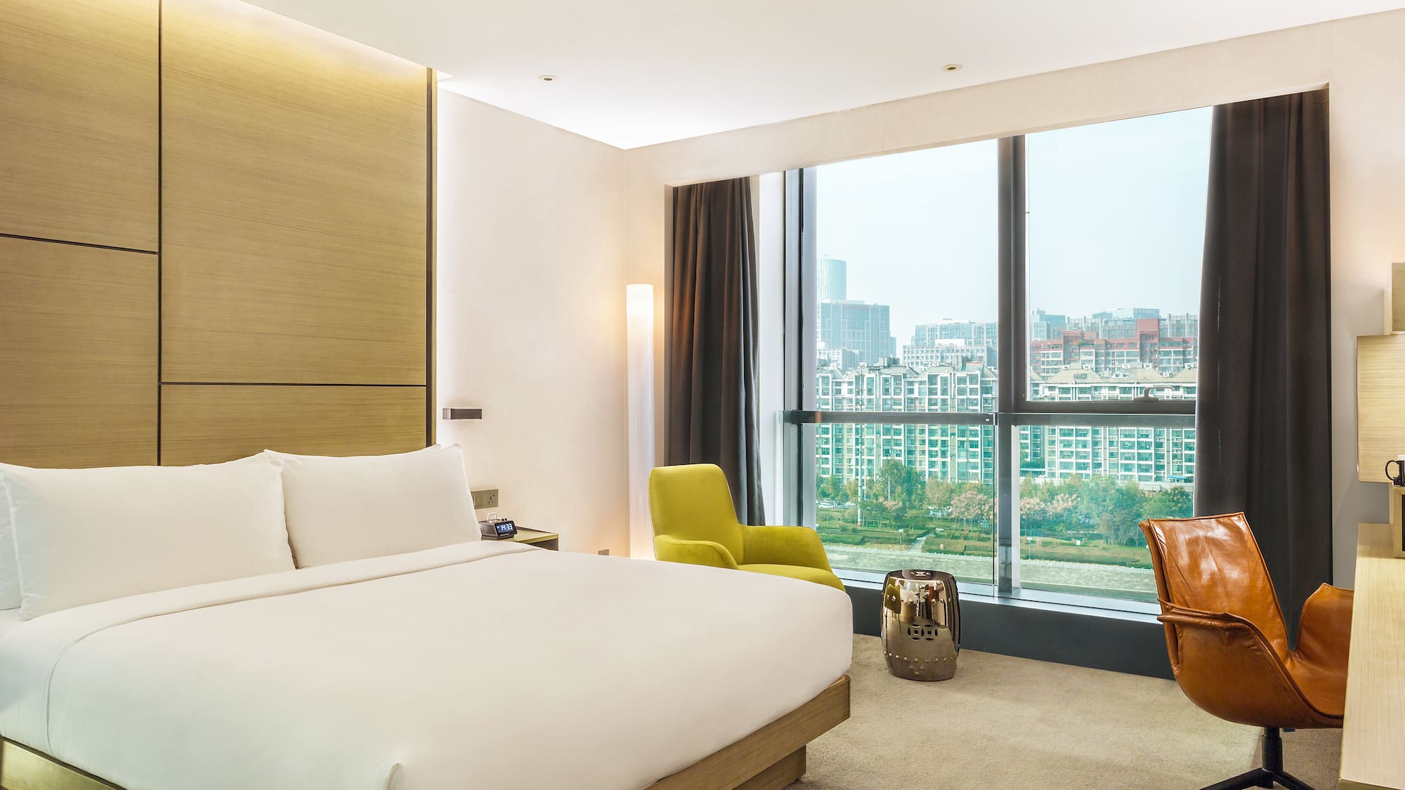 a bedroom with a large window and a large bed