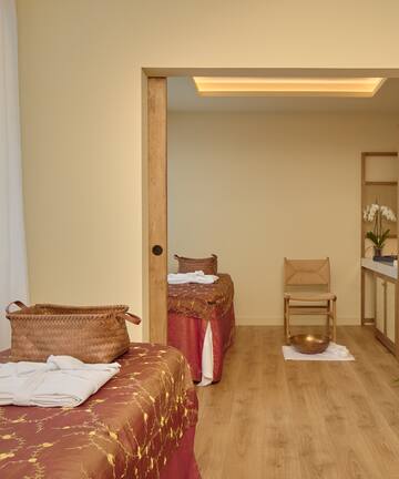 a room with two beds and a chair