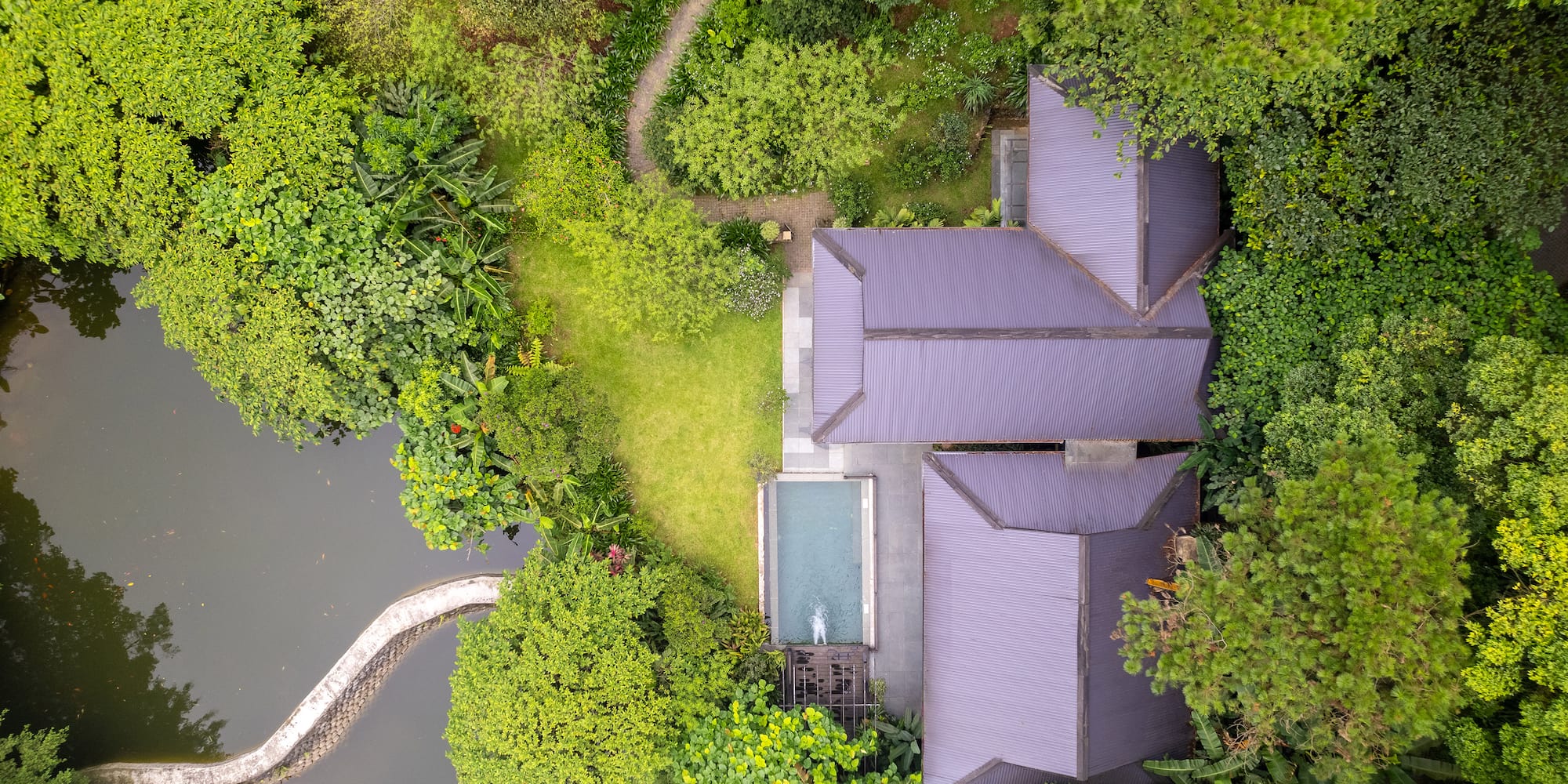 a house with a pool surrounded by trees