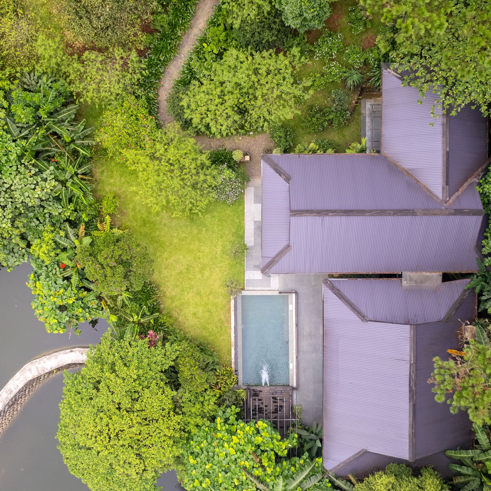 a house with a pool surrounded by trees