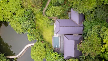 a house with a pool surrounded by trees