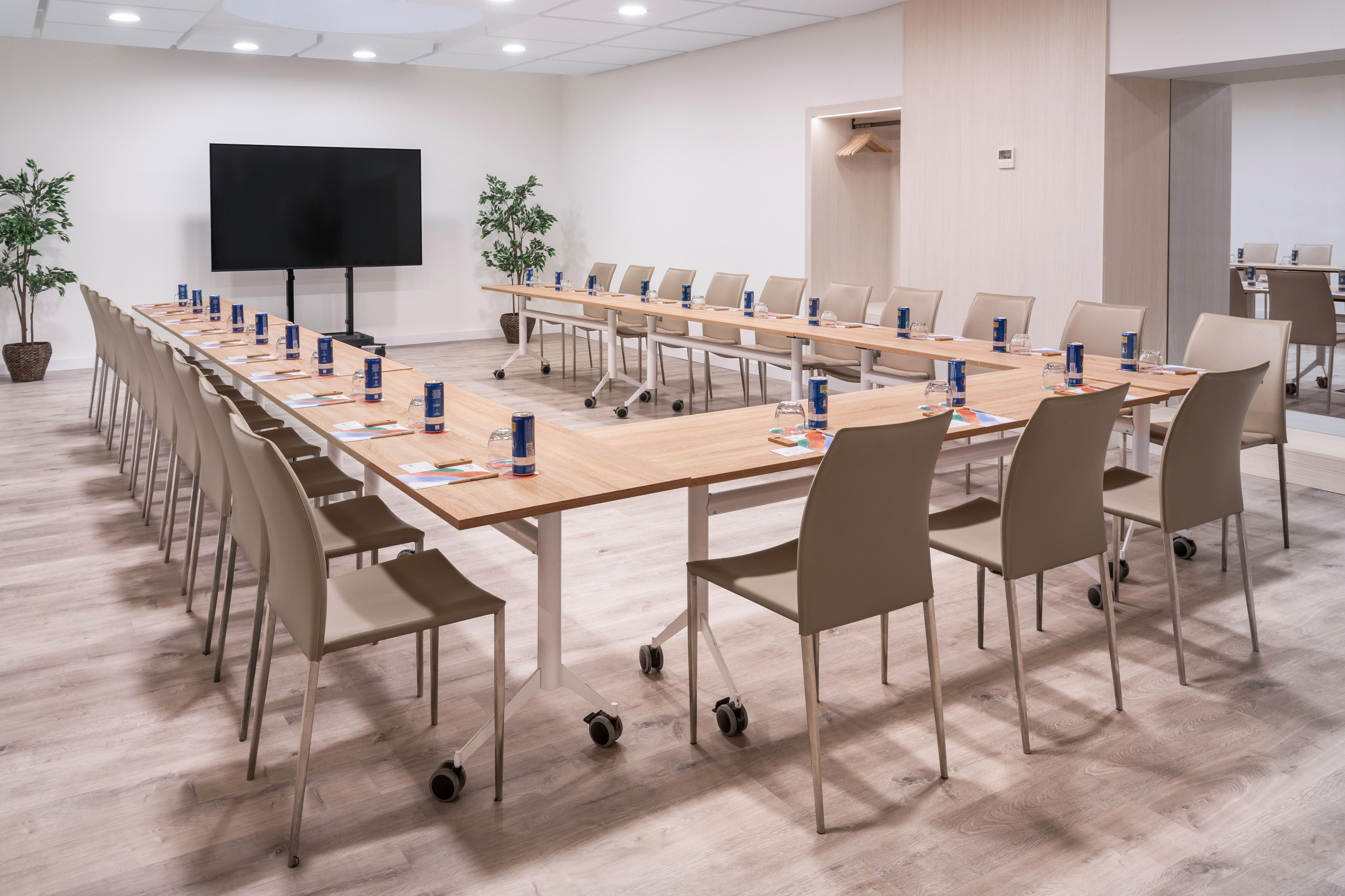 U-shaped conference room with large screen, ideal for meetings & events.