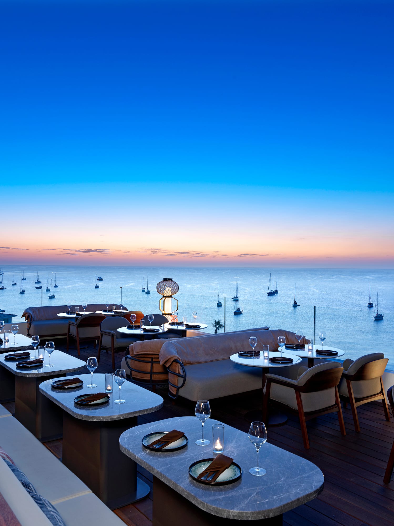a restaurant with tables and chairs overlooking the ocean