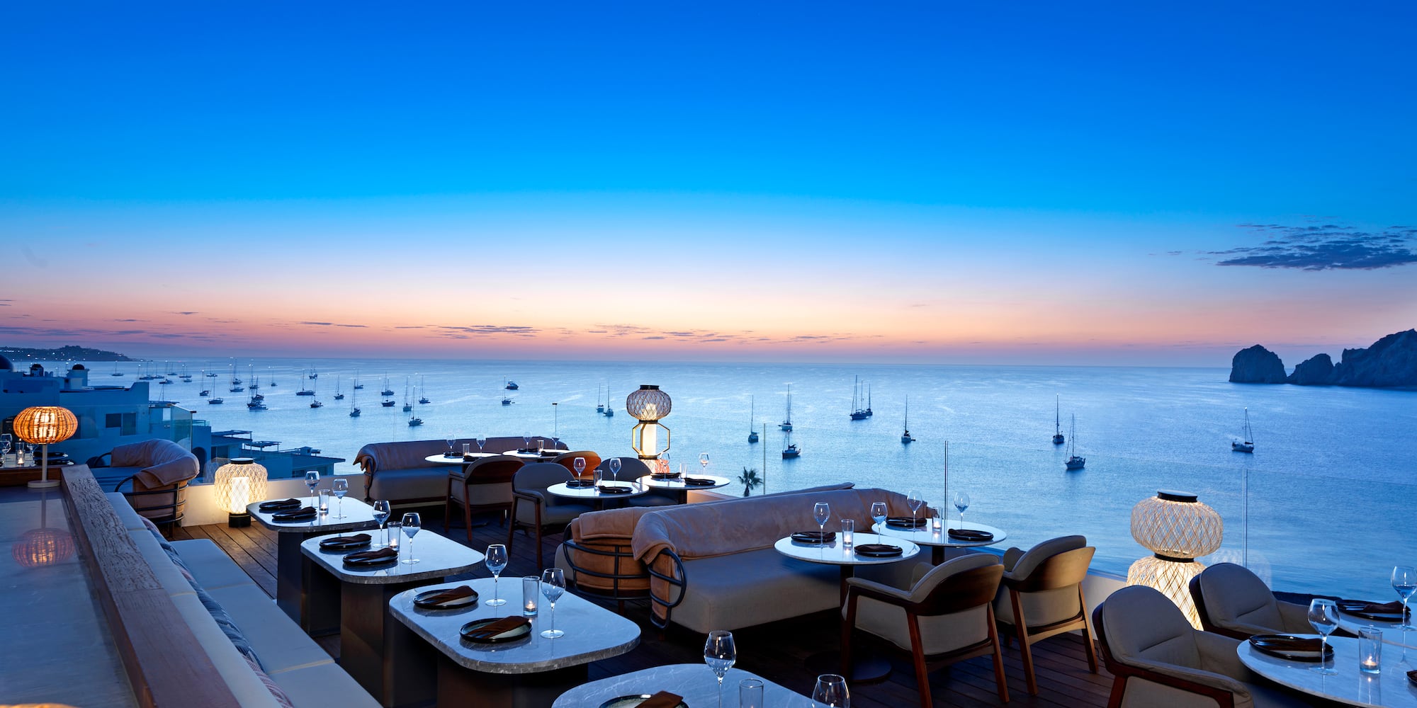 a restaurant with tables and chairs overlooking the ocean