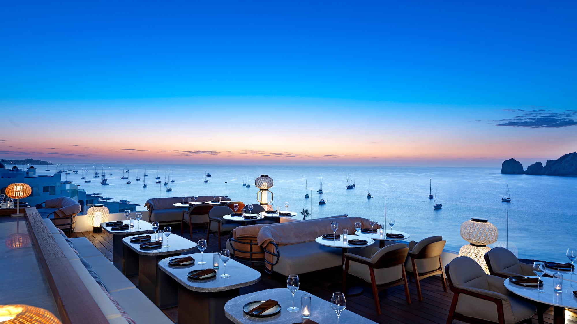 a restaurant with tables and chairs overlooking the ocean