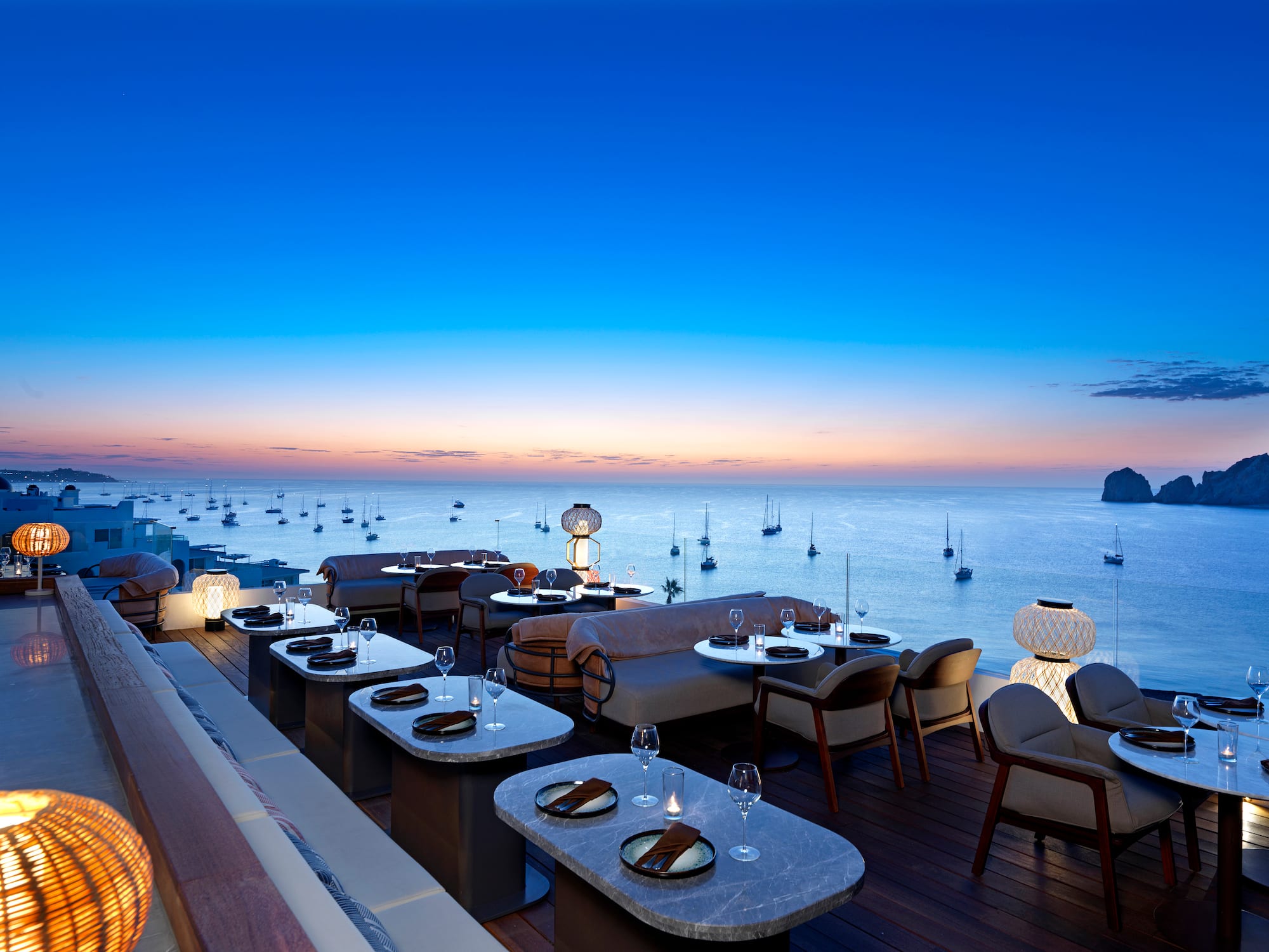 a restaurant with tables and chairs overlooking the ocean