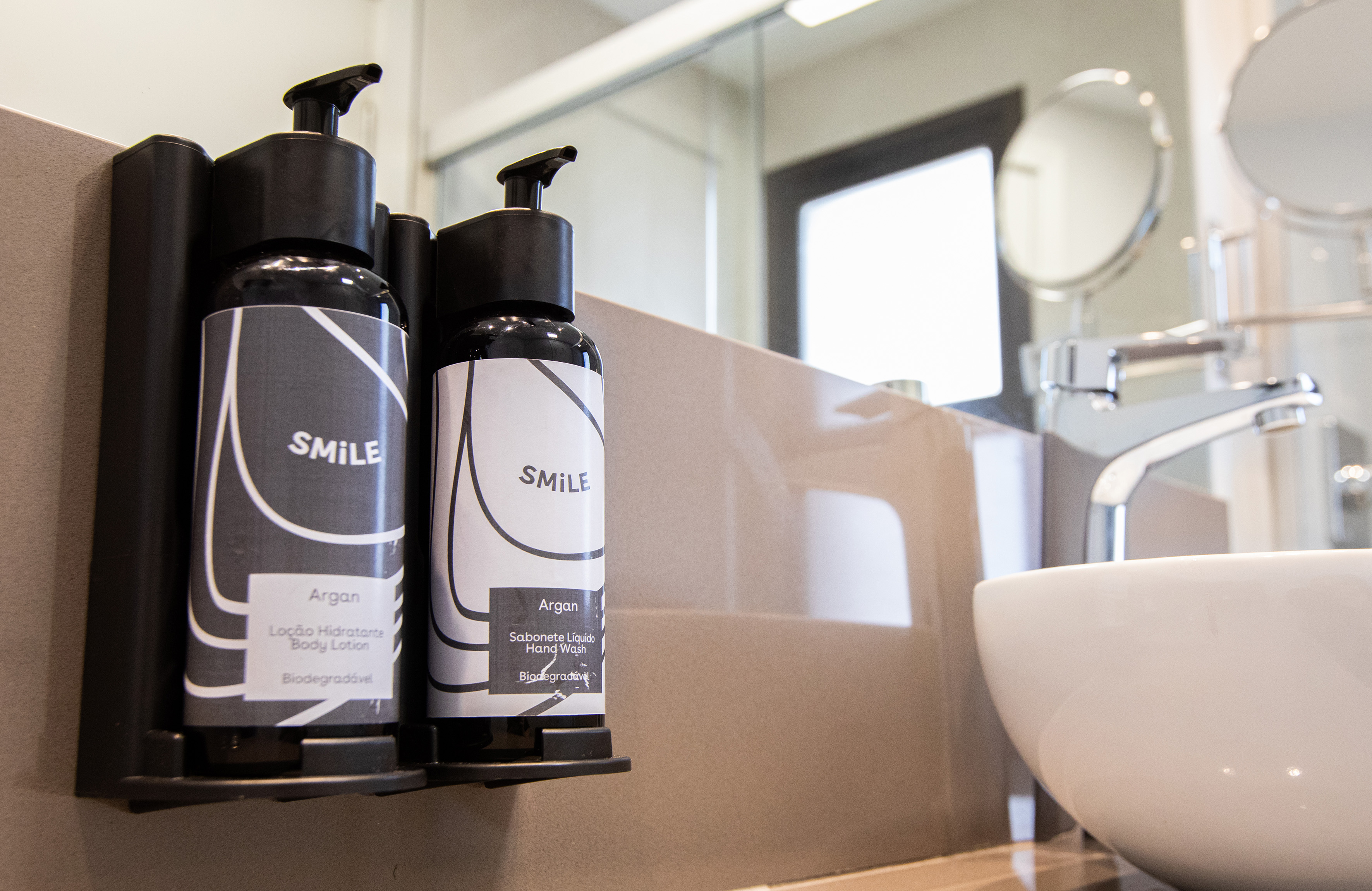 Argan Smile body lotion and hand wash dispensers in modern bathroom.