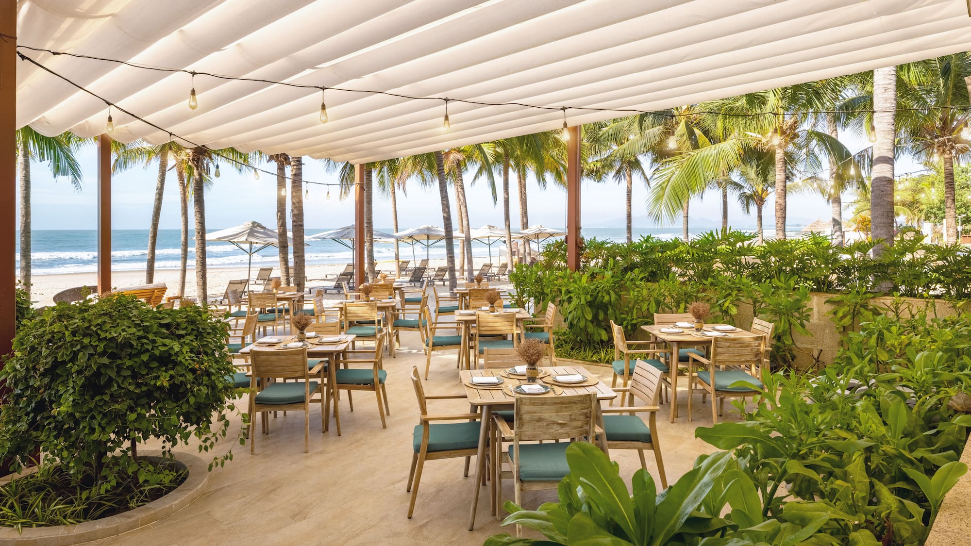 a restaurant with tables and chairs on a beach