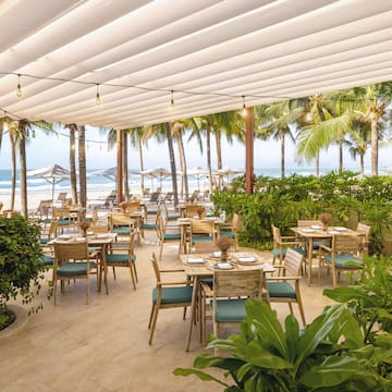 a restaurant with tables and chairs on a beach