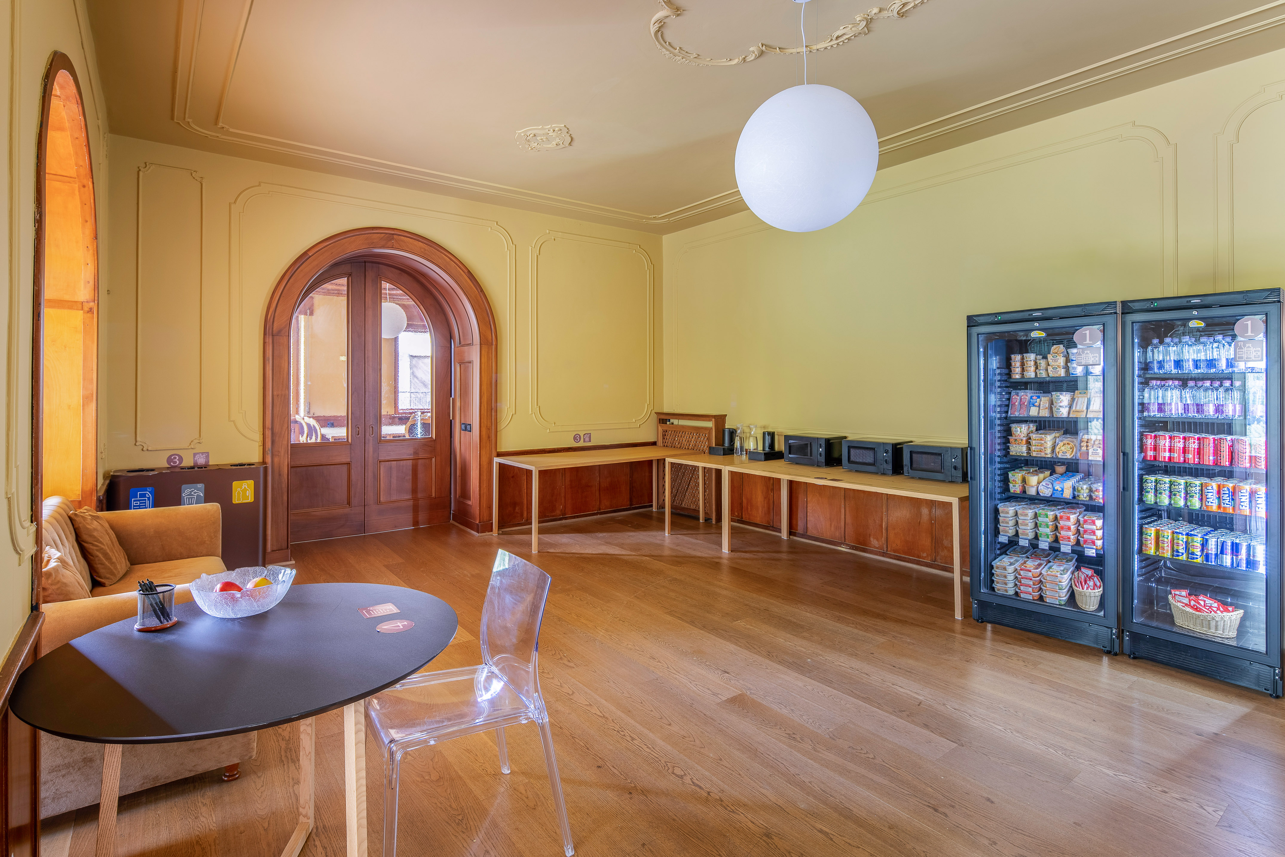 Bright break room with vending machines, microwaves, and seating area.