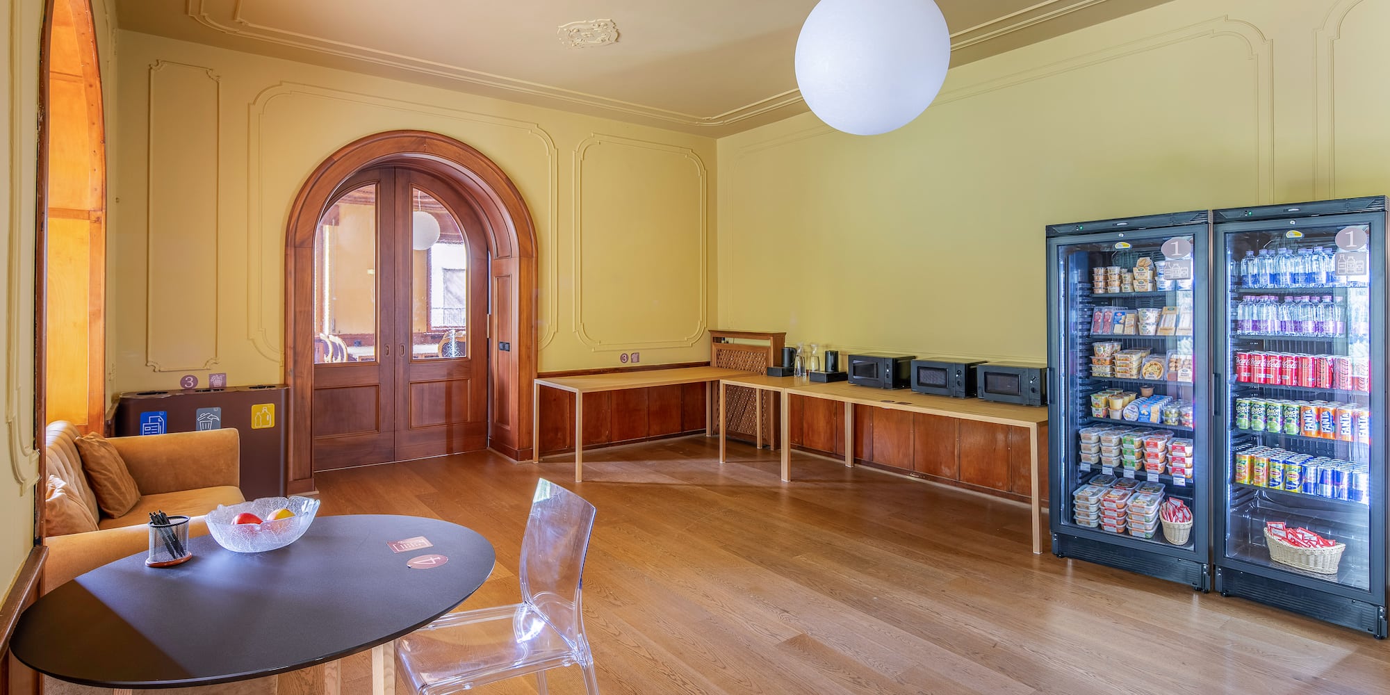 Bright break room with vending machines, microwaves, and seating area.