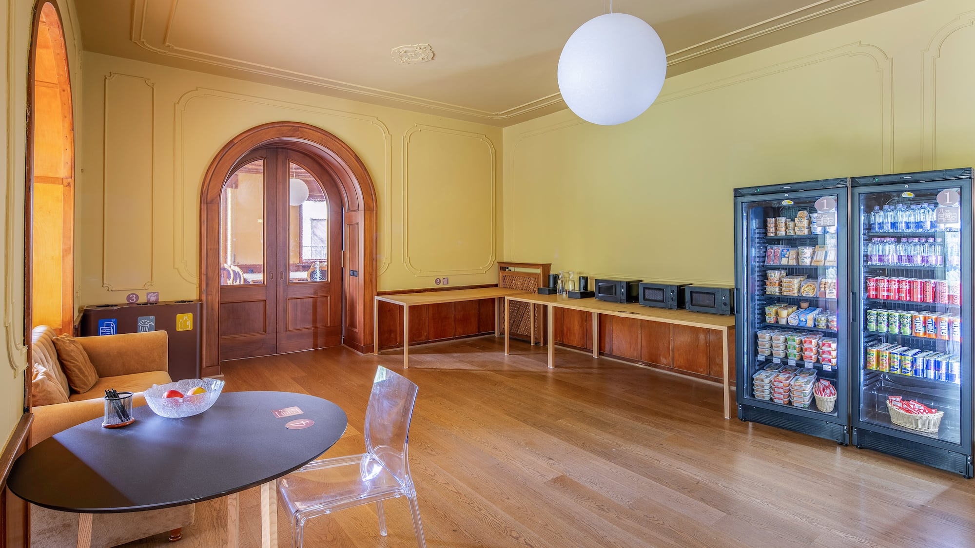 Bright break room with vending machines, microwaves, and seating area.
